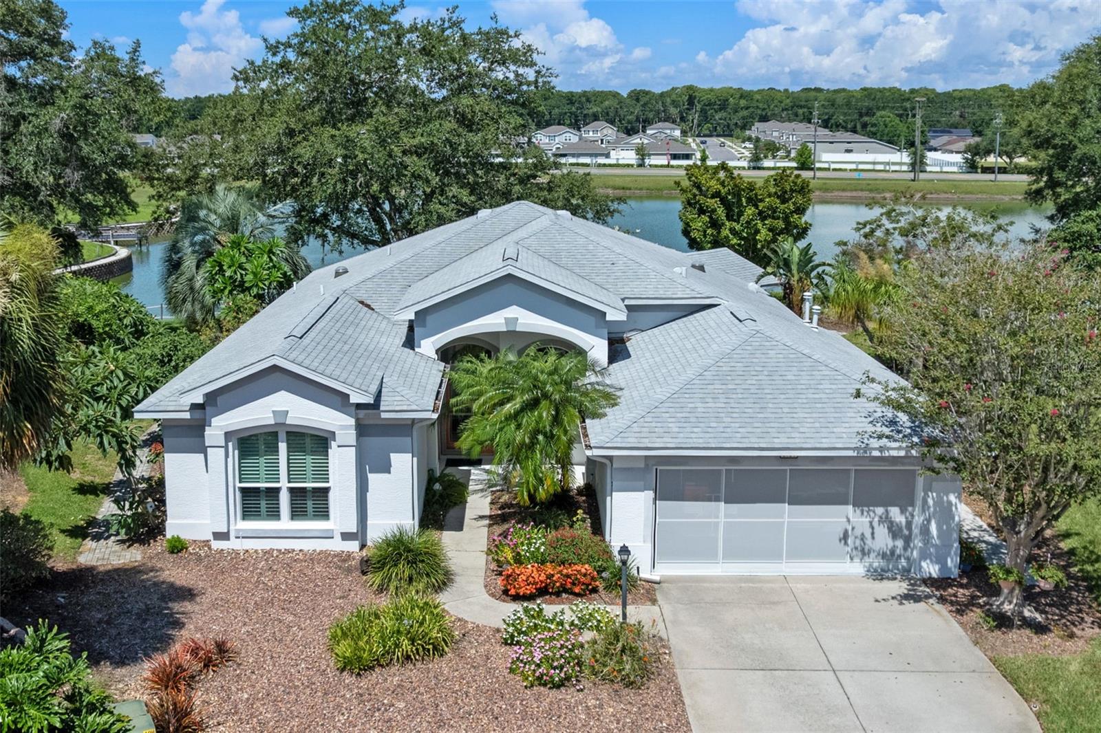 Here’s a rare opportunity to own a truly special home in the vibrant 55+ community of Royal Harbor—a custom-designed, one-owner residence tucked at the end of a quiet cul-de-sac with peaceful lake views of Royal Harbor's private, Lake Lamont. With only a select few homes surrounding this charming waterway, the setting is as exclusive as it is serene.
From the very beginning, this home was carefully tailored by the original owners, who made thoughtful modifications to the builder’s floor plan to enhance flow, maximize space, and take full advantage of the natural beauty just outside the windows. The result is a beautifully maintained two-bedroom, two-bath home with a private study that lives comfortably and feels effortlessly inviting.
Step inside and you’re welcomed by clean architectural lines, natural light, and an airy sense of openness throughout the main living and dining area. Generously proportioned ceilings stretch overhead, giving the space a comfortable yet elevated presence, while wide, sunlit views connect the interior to the surrounding landscape. Updated impact-rated, argon gas windows (2022) with classic plantation shutters offer both peace of mind and timeless appeal.
The kitchen is a standout, featuring updated cabinetry, crisp quartz countertops, a convenient breakfast bar, and stainless appliances. Natural light spills in from an overhead solar tube, keeping the space bright and cheerful throughout the day. A expansive dinette—perfectly positioned and surrounded by windows—frames calming views of Lake Lamont, making it the ideal spot to start your morning or unwind in the evening.
The main flooring is a rich, random-width Armstrong laminate, known for its durability and warm, natural wood look. The primary suite is a private retreat with tranquil lake views, an ensuite bath featuring updated cabinetry, quartz countertops, double sinks, a beautifully updated shower, and a jetted garden tub that invites you to relax in style. The second bedroom is thoughtfully separated for privacy and has direct access to an updated guest bath—ideal for overnight visitors.
The enclosed lanai extends your living space with vinyl windows and ceramic tile flooring, offering the perfect place to enjoy a breezy afternoon or evening by the lake. Outside, you'll appreciate the paver walkway that surrounds the home, along with a lovely rear paver patio ideal for grilling, casual gatherings, or simply enjoying the relaxing beauty of the backyard. And yes, the Club Car golf cart is included, so you can cruise the neighborhood from day one.
Living in Royal Harbor means more than just a great home, it’s a lifestyle. Residents enjoy access to a resort-style clubhouse, fitness center, heated pool and spa, tennis and pickleball courts, walking and biking trails, RV/boat storage, and a calendar full of social activities and neighborhood events. With its setting on the shores of Little Lake Harris, this community offers a scenic and active waterfront lifestyle that’s second to none.
This thoughtfully crafted home isn’t just where you live, it’s where you wake up to peaceful water views, host sunset dinners on the patio, and embrace a lifestyle that feels like a reward for a life well-lived.
