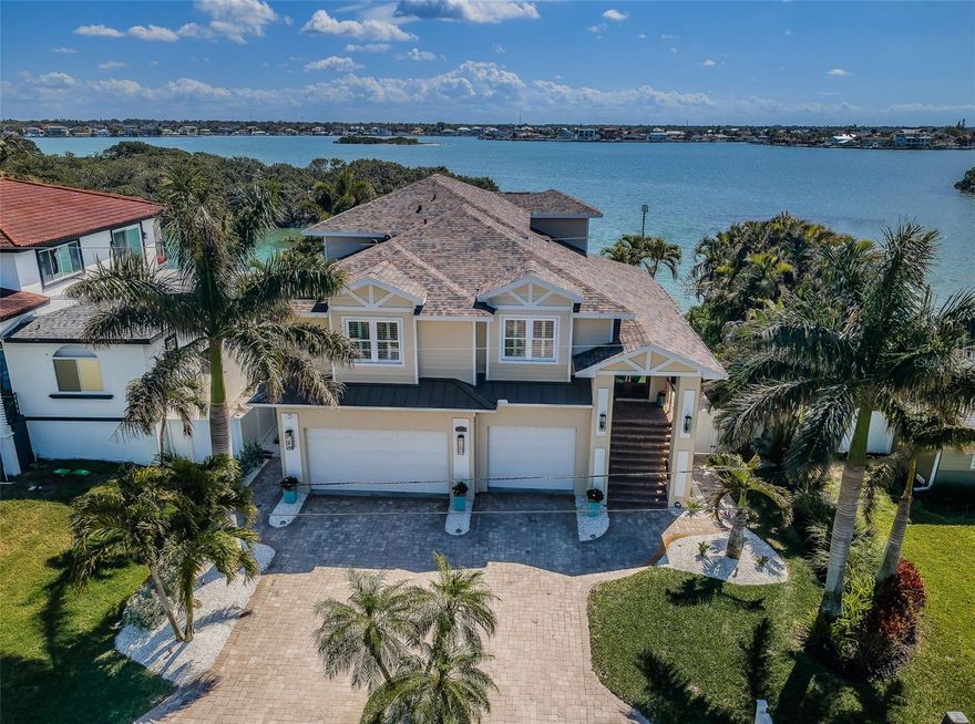 ENJOY THE BEST OF BOATING AND THE BEACH IN THIS BEAUTIFULLY UPDATED COASTAL LUXURY RESIDENCE! Located on the terrific boating water of the intracoastal waterway, and just a short five-minute walk to the beach, welcome to a home that breaths elegance and refinement! An appealing circular brick paver driveway introduces a lovely covered entry and wonderful views of the waterfront. Gorgeous Brazilian cherrywood floors, superb woodworking, fine window treatments and radiant lighting deliver a distinctive and inspiring allure. The resplendent living room area, with 13ft-high vaulted ceiling and exquisite custom built-in media/storage center, features pocketing sliding-glass doors that transition to 28ft wide covered luxury balcony with a motorized screen enclosure system. Pocketing sliders enable a fantastic indoor-outdoor living and entertaining experience. Overlooking the waterfront, your sumptuously-appointed kitchen makes cooking a true joy – with lavish marble and pounded granite surfaces, richly-tiled backsplash areas, generous coastal white cabinetry, high-end appliances including Wolf gas cooking, a large island bar and prep-center, a spacious pantry closet, and immediate access to two dining areas. The upper level is a dedicated owner’s suite with the grand bedroom and sitting area overlooking the intracoastal waterway; bedroom features his and her closets (hers is an oversized walk-in) and a private covered balcony with commanding views of the waterfront. The owner’s bath is a posh, pampering experience – with a beautifully encased jetted spa tub, beaded-board wainscoting, splendid his and her vanities and a walk-in glass shower enclosure. A separate split ½ level contains a large en suite bedroom with graceful full bath and walk-in closet, and a second large bedroom with walk-in closet - supported by an adjacent full guest bath with luxury finishes. Out back you’ll discover a dazzling pool/spa with posh tilework, a newly-installed Pebbletec finish, and a fabulous shellstone paver deck. The composite dock, with extensive shore power and water, supports a large deepwater (8ft of depth) boat slip with tie pole support for a 28ft beam. This exceptional residence has a 6 month new roof and enjoys tankless gas hotwater heating, whole-house water softening, modern custom handrails, 1000+ sqft of secure under-structure storage, Tesla vehicle charger, and Tesla whole-house battery backup system (with fully functioning solar panels in garage awaiting your installation). Home enjoys private “residents only” access to the beach and is a short drive from the dining, shopping and entertainment of Clearwater Beach and Indian Rocks Beach. An outstanding open waterfront value in Belleair Beach!