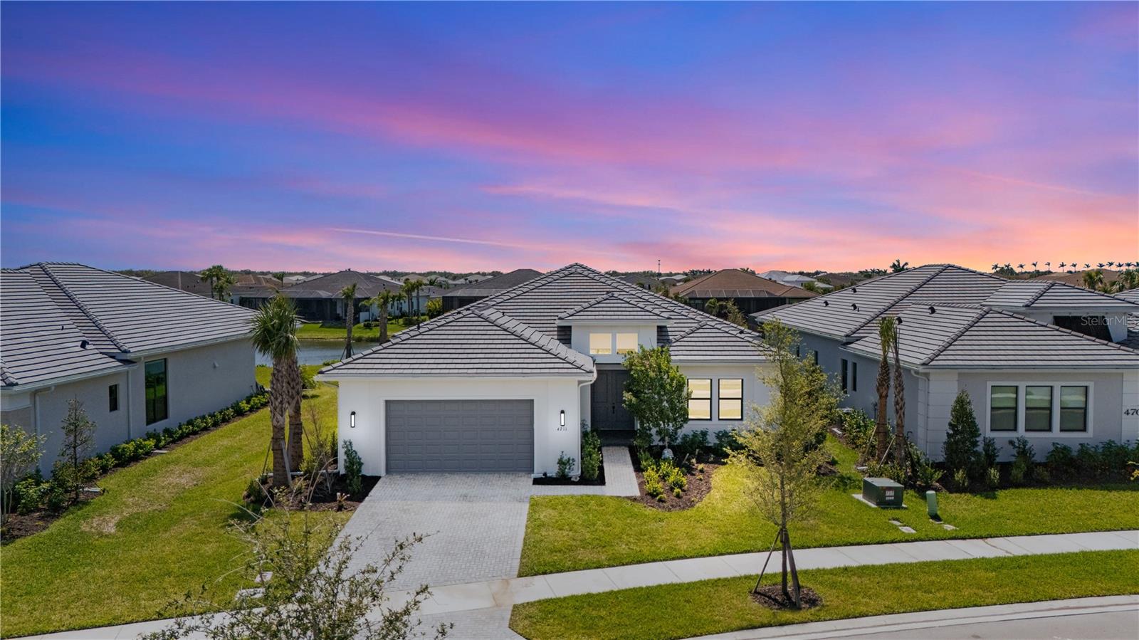 4711 Cedron Ct | Artistry Sarasota
A Rare Lakefront Setting. A Home That Just Feels Right.
From the moment you walk through the door, there’s something different about this home. The light hits you first—pouring through oversized windows, bouncing off crisp walls, reflecting from the lake just beyond the glass. The ceilings soar, the layout opens wide, and it all just feels bright, calm, and clear. It’s not overdone. It’s not trying too hard. It’s just right.
Set on one of the largest lakefront lots in Artistry, this home offers space that most new builds don’t. The backyard is deep, beautifully landscaped, and fully framed by nature—with no rear neighbors in sight. You’ll notice the quiet immediately. No road noise. No construction. Just birds, breeze, and water. And because the property is high and dry, there’s no flood insurance required and no CDD fees to worry about. The lot has also been thoughtfully prepped for a future pool—gas, water, and drainage lines are already in place, so you can build your dream outdoor living space without delay or added hassle.
Inside, the home is clean, modern, and move-in ready. Built in 2024 and gently lived in, it offers timeless design with upscale finishes throughout. The kitchen is a standout—full quartzite slab backsplash, custom two-tone cabinetry, 36-inch gas cooktop, wall oven and microwave, and a large island that opens right into the main living area. Every detail was selected for both form and function.
The primary suite sits at the back of the home with peaceful lake views and direct access to the lanai. The ensuite bath includes dual vanities, a frameless glass shower, and an oversized walk-in closet. Two guest suites and a separate den offer space for work, guests, or quiet retreat, all while maintaining a layout that flows effortlessly.
This is one of the few homes in Artistry that checks every box—size, view, privacy, layout, readiness. The section of the community it sits in is already built out, so what you see is what you get—no nearby construction noise, no uncertainty, just a finished, peaceful street. And the location is unbeatable: 15–20 minutes to downtown Sarasota, Waterside, UTC, Lakewood Ranch, the beaches, and top-rated medical and golf facilities.
If you’ve been looking at new construction but want something that’s already complete, on a premium lot, and full of light, 4711 Cedron Ct might be exactly what you’ve been waiting for. It’s not just a pretty home. It’s a smart one. And it’s ready now.