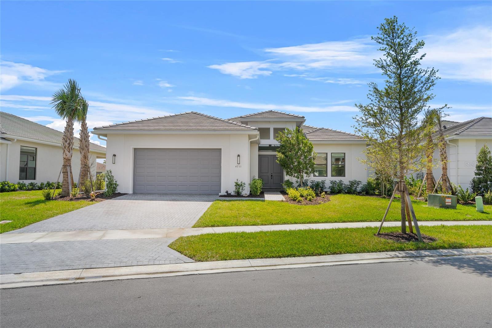Where Modern Elegance Meets Serene Lakefront Living
Step inside this light-filled Van Gogh model by Kolter Homes and experience the perfect blend of open space, refined finishes, and everyday functionality. Set on a quiet interior street in one of Sarasota’s most desirable gated communities, this home offers tranquil lake views, an expanded lanai, and a layout designed to adapt to your lifestyle—whether you're entertaining, relaxing, or working from home.
Clean architectural lines, soaring ceilings, and a soft, neutral color palette create a sense of calm the moment you walk in. The main living space flows effortlessly around a chef’s kitchen featuring a quartzite backsplash, 36-inch gas cooktop, wall-mounted oven and microwave, oversized island, and generous storage.
The expanded primary suite is a standout—featuring bay-style windows that bring in natural light and frame sweeping lake views. The en-suite bath includes a frameless glass walk-in shower, dual vanities, and a large walk-in closet. Two guest bedrooms offer privacy and comfort, while the den—enclosed with double doors—offers true flexibility. Easily converted into a fourth bedroom, office, or media room, or opened up into the living area, this space adapts to your needs.
Out back, the extended lanai faces the water and provides the perfect setting for outdoor dining or morning coffee. The backyard has already been pre-plumbed for a pool, with gas, water, and drainage lines installed—saving you time and thousands in future build costs. A tandem three-car garage offers space for additional vehicles, a golf cart, a workshop, or gym setup.
This home is located on a uniquely shaped lot offering a bit of extra width and depth compared to nearby homes, allowing more room to personalize your outdoor living. It sits in a completed, quiet section of Artistry—free from construction noise or traffic—yet just 15–20 minutes from downtown Sarasota, Waterside Place, UTC, Lakewood Ranch, and the Gulf beaches.
Now offered at $1,050,000, this home is priced to sell and includes over $100,000 in thoughtful builder upgrades. For a limited time, the seller will cover one full year of HOA dues with a full-price offer, and buyers may also qualify for reduced mortgage rates through our preferred lender.
With no CDD fees, low HOA, and no flood insurance required, this is a rare opportunity to own a move-in ready, lake-facing residence in one of Sarasota’s premier communities.