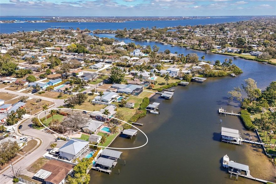 Perfectly positioned on a sprawling corner lot along the tranquil waters of Warners West Bayou, this inviting 3BD/2BA residence captures the essence of Florida waterfront living. A sweeping paver circular driveway and mature shade tree create an unforgettable first impression, while the two-car garage and detached workshop offer exceptional flexibility for hobbies, storage, or creative pursuits. Inside, warm wood accents and exposed beams frame the expansive main living areas, where skylights pour in natural light. The thoughtfully designed kitchen features wood cabinetry, a brick backsplash with custom hood detail, new stainless appliances, and a center island. Large windows throughout the home frame lush greenery and water views, creating a bright yet relaxed coastal atmosphere. A spacious family room offers an additional gathering space, ideal for entertaining or relaxing evenings at home. French doors open to the backyard where a private pool overlooks the bayou, creating a beautiful backdrop for outdoor living. The dock and boathouse extend your access to the water, making it easy to enjoy boating, fishing, or simply soaking in the view. Just a short drive to the stunning Gulf beaches of Anna Maria Island, you’ll enjoy quick access to sugar sand shores, waterfront dining, and all that makes this area so desirable. A new roof was installed in 2025 and the pool pump has been recently replaced, offering valuable updates while leaving room to make the home your own.