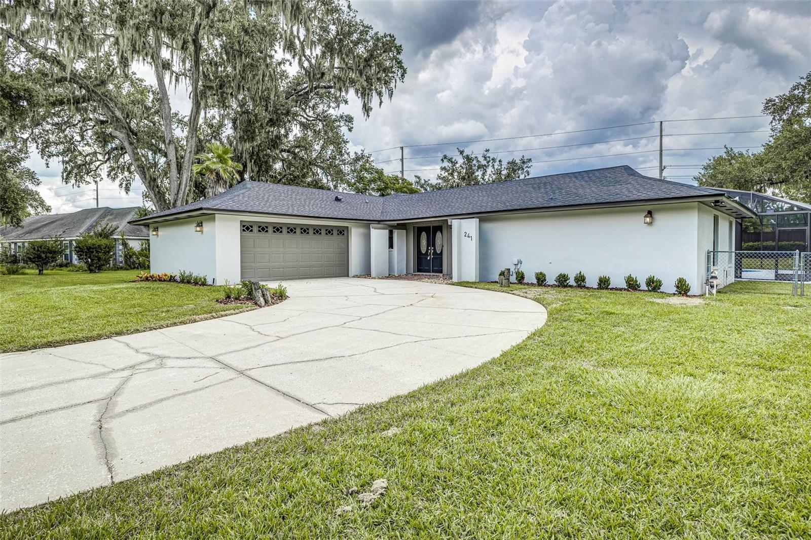 Welcome to your dream home in the highly sought-after Christina Lakes neighborhood in south Lakeland! This beautifully updated 4-bedroom, 3-bath pool home with a spacious 2-car garage sits on a generous .52-acre lot, surrounded by mature oak trees and charming curb appeal. Inside, you’ll love the open, triple-split floor plan featuring a large family room with a stunning floor-to-ceiling brick fireplace that flows seamlessly into the chef’s kitchen. The kitchen boasts granite countertops, rich wood cabinets extending to the ceiling, a breakfast bar, brand-new stainless steel appliances including a glass cooktop, double wall ovens, built-in microwave, under-cabinet lighting, and a stylish new tile backsplash. Throughout the home you’ll find tile flooring, new luxury vinyl plank in the main living areas and primary suite, and plush new carpet in the guest bedrooms. The luxurious master suite offers direct access to the pool, two walk-in closets, dual sinks with a separate vanity, and a spacious walk-in shower. Additional bedrooms are generously sized, with the fourth bedroom perfectly suited for in-laws, teens, or guests, featuring its own near-by bath with pool access—ideal as a dedicated pool bath. Step outside to enjoy the screened-in pool and covered lanai, perfect for entertaining or relaxing. The fenced backyard includes a shed, established Saint Augustine sod, and irrigation. Other upgrades include: new roof (2025), new hot water heater, A/C (2022) freshly painted interior and exterior, brand-new baseboards, large utility room with quartz counters and built-in laundry features. With a large yard, driveway, and 2-car garage, this home has it all. Located in the desirable Christina neighborhood, this home offers convenience, comfort, and elegance all in one. Don’t miss your chance to own this south Lakeland gem—schedule your private showing today!