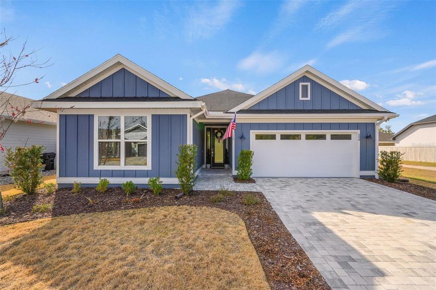 Located in the highly sought-after Laureate Village community in the popular Jonesville area of SW Gainesville, this 4-bedroom, 3-bathroom home truly feels like new! Featuring a desirable 3-way split floor plan for added privacy, this home offers thoughtful design and modern finishes throughout. Luxury vinyl plank flooring flows through the main living areas, while the stylish kitchen showcases quartz countertops, stainless steel appliances, gas cooktop, wall oven and microwave, stainless hood vent, and bar-top seating. The spacious living room is highlighted by a double tray ceiling and designer touches. The primary suite offers a large bathroom with double vanity, oversized shower, and a generous walk-in closet with custom solid wood shelving. Two additional guest bedrooms also feature spacious walk-in closets. Enjoy added privacy with an easement on one side of the lot, creating a corner-lot feel. Conveniently located near the resort-style amenity center featuring a beach-entry pool, gazebos, pickleball courts, basketball court, and playground.