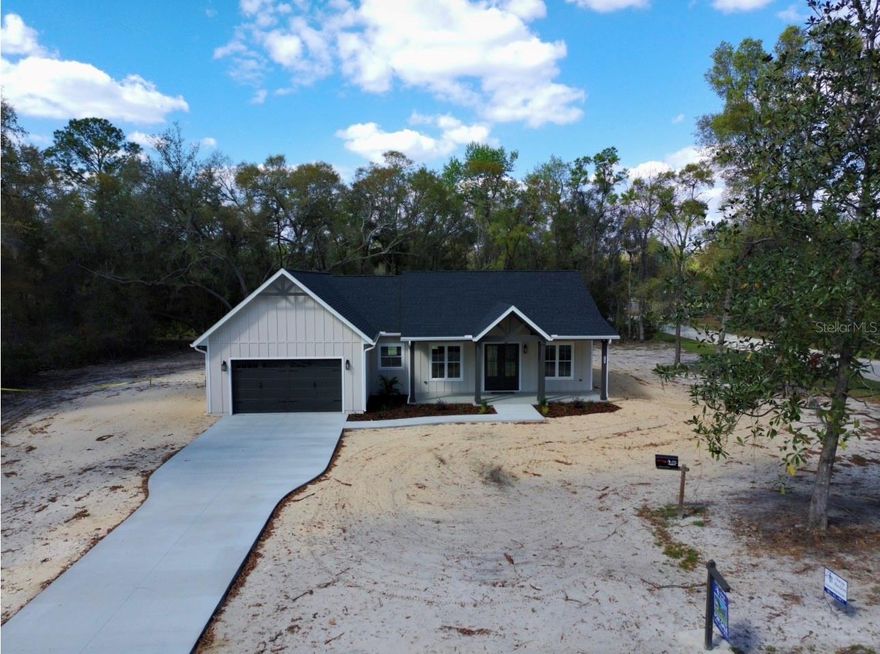 Experience the perfect blend of luxury craftsmanship and laid-back country living in this exceptional custom-built residence in Chiefland. If you’ve been dreaming of a high-end custom home without the time, stress, and uncertainty of building—this is your opportunity.
Situated on a spacious 1-acre corner lot, on a paved road, this stunning 3-bedroom, 2.5-bath new construction home is a true showstopper, thoughtfully designed with impeccable attention to detail at every turn. From the moment you arrive, the long concrete driveway, striking curb appeal, oversized columns, and charming farmhouse aesthetic set the tone for what awaits inside.
Step through grand double entry doors into a beautifully appointed interior featuring soaring 10-foot ceilings, 8-foot doors throughout, and an open-concept layout designed for both everyday living and entertaining. The living room is anchored by a custom built-in electric fireplace, complemented by designer cabinetry and shelving—creating a warm yet elevated focal point.
Luxury vinyl plank flooring flows seamlessly throughout the home, enhancing both style and durability. The chef’s kitchen is a true centerpiece, boasting custom cabinetry, a massive quartz island with convenient pop-up outlets, a farmhouse sink positioned beneath a picturesque window, stainless steel appliances, and a stylish backsplash. Just beyond, the dream pantry offers abundant shelving, an additional farmhouse sink, and even a charming chalkboard wall—perfect for organizing your daily life in style.
Attention to detail continues with upgraded lighting, custom wall features, and a thoughtfully designed drop zone. A well-placed half bath provides convenience for guests, while the spacious laundry room is outfitted with extensive cabinetry for optimal functionality.
The owner’s retreat is a private sanctuary, featuring a generously sized bedroom, an oversized walk-in closet, and a spa-inspired bathroom complete with a long double vanity with tower storage, an expansive walk-in shower, and a private water closet.
Two additional bedrooms are well-sized and share a beautifully finished full bath with a tiled surround and custom cabinetry touches, maintaining the home’s cohesive, high-end feel.
Step outside through French doors to a large covered back porch—ideal for relaxing and taking in the peaceful surroundings of your expansive backyard.
Enjoy the best of both worlds with a serene country setting just minutes from everyday conveniences. Located within 10 minutes of shopping, dining, and medical facilities, and close to the natural beauty of the Suwannee River and area springs, you’re also only about 35 minutes from the coastal charm of Cedar Key and the Gulf of Mexico.
This is more than just a home—it’s a lifestyle upgrade. A must-see property where quality, comfort, and thoughtful design come together seamlessly.