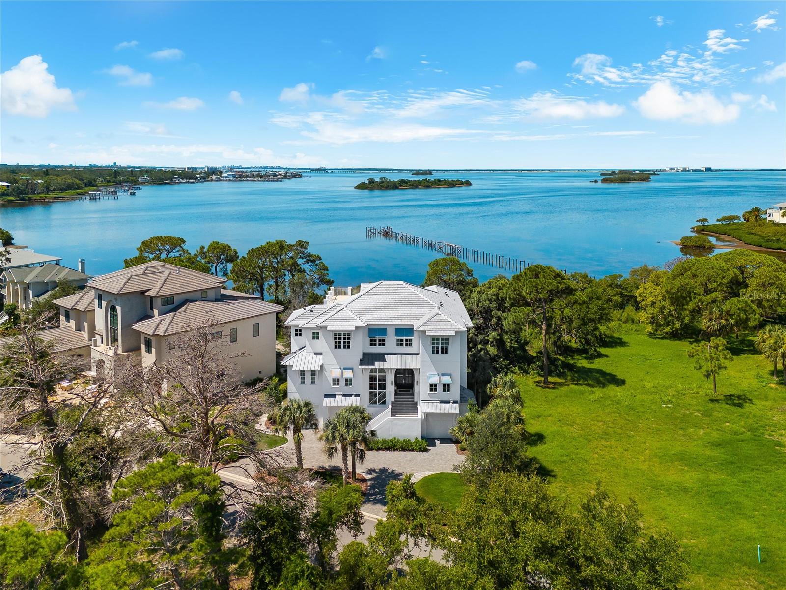 Under contract-accepting backup offers. Boldly architectural, exquisitely styled, and rich in provenance, 885 Seaview Drive is a one-of-a-kind waterfront estate where editorial design meets masterful construction. Perched on 45 feet of bayou frontage in Crystal Beach’s coveted Turtle Beach enclave, this newly remodeled 7-bedroom, 7-bath residence is the embodiment of coastal sophistication—designed for those who demand beauty, quality, and quiet exclusivity. From the moment you enter, the tone is unmistakable: this is a designer’s home. A crystal chandelier floats overhead with an automated lift system. Soaring 22-foot ceilings and floor-to-ceiling glass create a luminous great room with panoramic views of Sutherland Bayou. A dramatic stacked-stone ethanol fireplace anchors the space, flanked by 10-foot sliding glass doors that dissolve the boundaries between indoors and out.
Meticulous 2025 upgrades elevate every inch of this home. A brand-new roof and expansive fourth-floor sundeck by Arry’s Roofing, fresh exterior and interior paint, custom light fixtures, and professionally finished garage and gym flooring by Haven Floors—used in luxury fitness studios across the country—set a new benchmark in form and function. The ground-level garage is fully climate-controlled, featuring Mitsubishi split systems and epoxy flooring, transforming it into a versatile flex space for wellness, recreation, or creative pursuits.
The chef’s kitchen is a functional work of art—anchored by a 6-burner Wolf gas range, Sub-Zero refrigeration, quartz countertops, a large prep island, and hand-selected finishes that balance warmth with precision. Entertain effortlessly in the formal dining room, flow into the open-concept patio, or retreat to the private media lounge and executive office.
A residential elevator offers seamless access to all levels, including the serene owner’s suite with water views, a spa-inspired bath, dual vanities, an oversized walk-in shower with body jets and rain heads, and a 14’ x 11’ custom closet space awaiting your vision. Each additional bedroom features a private en-suite bath and a bespoke walk-in closet handcrafted by a master cabinetmaker from the East Coast.
Outside, the experience is resort-level. An 18x30 salt-chlorine water pool with oversized sun shelf glimmers beneath the Florida sky. Surrounded by more than 1,100 square feet of travertine tile, this outdoor haven includes a heater, chiller, and a programmable LED light show foundation—perfect for both quiet evenings and grand entertaining. Newly installed aluminum fencing provides discreet security without interrupting the water views.
But this home is more than beautiful. It is recognized. Every bedroom has been featured in Pottery Barn campaigns. The entire residence has served as the backdrop for global brands including Elle Decor, Pottery Barn Kids & Teen, HomeGoods, Target, Wayfair, and Better Homes & Gardens. The designer herself has been showcased on HGTV, Good Morning America, Southern Living, Seventeen, Real Simple, and People Magazine.
Located in one of the Gulf Coast’s most charming and laid-back communities, this home offers direct access to the Pinellas Trail, sunsets at Live Oak Park, golf-cart-friendly streets, and top-tier schools including Palm Harbor University High. This is not just a home—it’s a legacy property, a statement, and a story waiting to unfold.