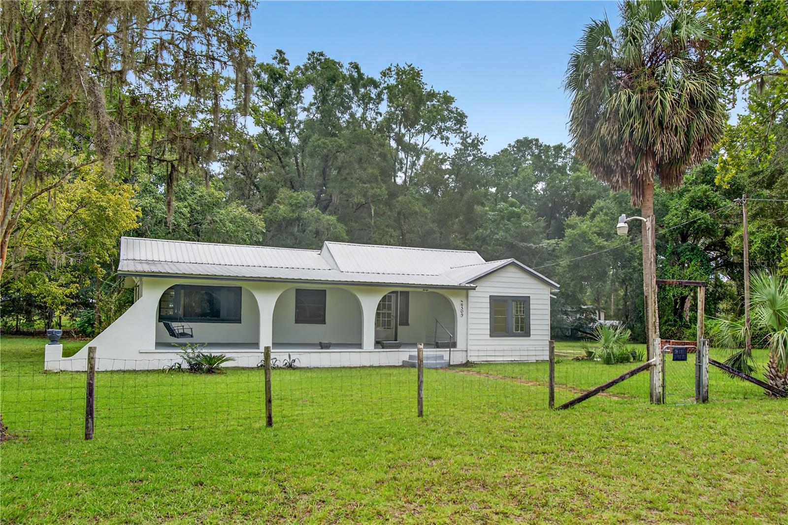 This well-maintained 3 bedroom, 1 ½ bathroom home sits on 0.66 acres in the Waccasassa Campsites neighborhood of Trenton, FL. Inside, you will find a bright and welcoming living area with plenty of space for family and friends to gather. The kitchen offers ample cabinet storage and a functional layout, while the bedrooms are generously sized to provide comfort and flexibility. The master bedroom features its own private half bath for added convenience, and the home has been cared for with attention to detail, making it move-in ready. A small outbuilding offers extra storage for tools or recreational equipment. The home boasts a large front concrete porch with northern exposure, perfect for relaxing in the shade, as well as a covered side porch with western exposure to take in the beautiful Florida sunsets. Located just a short drive to both Trenton and Newberry, you’ll have access to local shops, dining, and schools, with the added convenience of the new Publix in Newberry for all your grocery needs. This home is a wonderful opportunity for anyone looking for a well-kept property in a peaceful North Florida community.