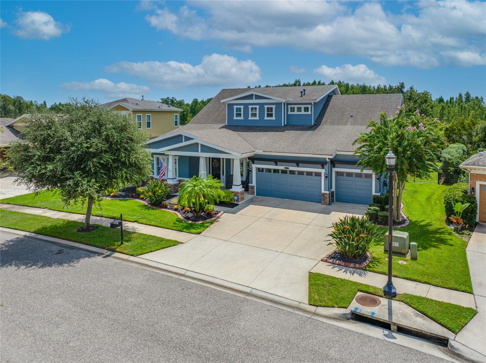 Welcome to this exceptional Longboat II by Homes by WestBay, a thoughtfully designed and extensively upgraded residence on one of Connerton’s most desirable streets, offering gorgeous private views of the wooded preserve behind the home. Featuring 4 bedrooms, a den/office, a spacious bonus room, 4 full bathrooms, and 3,713 sq ft of living space (5,022 sq ft under roof), this home blends luxury, function, and lifestyle. From the moment you arrive, the home’s striking architectural elevation, stone accents, extended covered front patio, and 8 foot glass entry door with sidelights set the stage. Inside, soaring 12 foot ceilings in the foyer and Grand Room create a dramatic sense of space. The Grand Room is anchored by a floor to ceiling stone feature wall with a 7'x12' electric fireplace, custom cabinetry, and built in surround sound. Seamless indoor outdoor living follows with a full pocket wall of sliding glass doors that open to the extended covered lanai. At the heart of the home, the gourmet kitchen boasts stainless Samsung appliances including a 4 Door Flex refrigerator, beverage fridge, 5 burner gas cooktop with stainless lighted exhaust hood, and a KitchenAid double wall oven. White wood cabinetry with crown molding is complemented by an extended wall of cabinets and counters, paired with a glass tile backsplash, polished Moondust quartzite counters, and an oversized island with granite undermount sink, touch on faucet, and an extended countertop for seating. The first floor primary suite is a private retreat with a tray ceiling and spa style bathroom featuring dual vanities, a garden tub, a large tiled walk in shower, and a massive custom designed walk in closet. Two guest bedrooms share a full bath, and there is also another full bath with direct lanai access, perfectly positioned to serve as a future pool bath. A versatile den/office with walk in closet is also located on the main level. Upstairs, a large bonus room with built in surround sound includes a walk in storage closet and two sets of glass French doors opening to a covered balcony overlooking tranquil wooded scenery. Also upstairs is a 4th bedroom with ensuite bath. The oversized 0.26 acre homesite is fully fenced and provides plenty of room to add a pool. Recent upgrades include both HVAC systems replaced in 2024 with high efficiency Bryant units and WiFi Ecobee thermostats, fresh exterior paint, new landscaping with black lava rock and upgraded sprinklers in 2023, luxury vinyl flooring, plantation shutters, custom closets, upgraded fixtures and lighting, whole home water softener and filtration system, garage epoxy floor, and ceiling storage racks. Connerton residents enjoy world class amenities including a 10,000 sq ft clubhouse, resort style pool with swim lanes, interactive splash park and waterslide, fitness center, tennis and pickleball courts, basketball, playgrounds, dog parks, an onsite café, and miles of walking and biking trails. Year round programming and events add to the vibrant lifestyle!