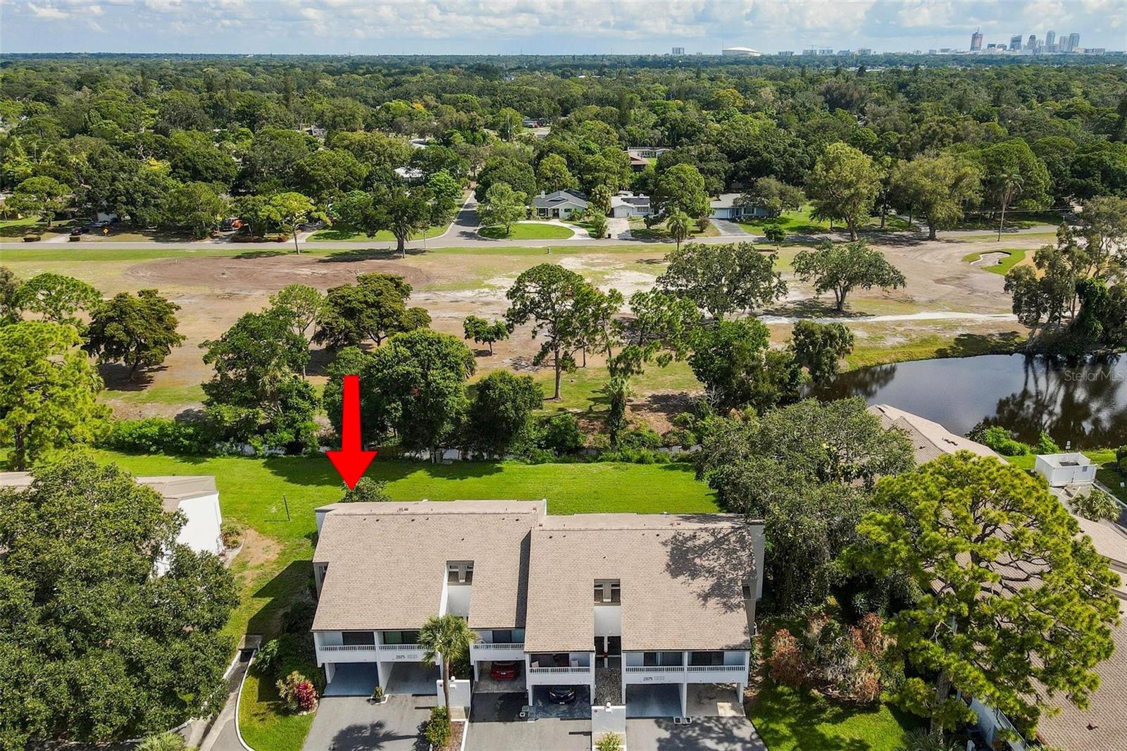 Want water views without being in a flood zone? Step into this two-story condo with immense potential. Right off the bat, you'll notice the amazing staircase done by a high-level architect. It also features a corner lot with an attached carport. One of the highlights of this property is its breathtaking view of the serene ST. PETERSBURG COUNTRY CLUB visible from the living area, master bedroom, and one of two balconies in the unit. Imagine waking up to panoramic views of lush greenery every morning or enjoying a peaceful sunset from your private balcony. Focus your attention on both bedrooms having their own private bathrooms, ideal for privacy. This would be amazing for someone with a little vision who wants to add their own unique style. The condominium complex features a private pool, a private tennis court, and the lowest HOA you will find in this price range. The outsides of all units were also repainted within the last year. 10 minutes to Downtown, 14 minutes to picturesque Pass-a-Grille Beach, 2 minutes to Lakewood High School, and 23 minutes to Tampa International. We do have a quote from contractor for work coming out at $60,150.