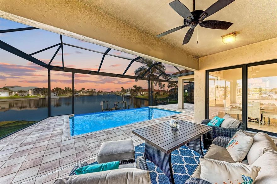 Fall in love with this 2015 built custom waterfront pool home with 3 bedrooms, 3 bathrooms, a den, a 3-car garage, long water views and a dock with lift in your backyard with beautiful sunrise views and gorgeous sunsets from the front porch over St. Andrews South Golf Course! BE SURE TO CLICK THE FULL VIRTUAL TOUR LINKS FOR DETAILS and ASK FOR THE FEATURES SHEET! This home has it all, including amazing curb appeal and fabulous finishes. As you approach the double glass front door, notice the upgraded landscaping, large paver circular driveway, and all impact windows/doors for easy lock & leave hurricane preparation! Inside the foyer, be wowed by the view over the incredible long water canal and pool that beckons! The foyer is open to the spacious great room with a wall of sliding glass doors that open to the pool/lanai with vanishing edge, and panoramic pool cage with unobstructed views! To the right an office/den is ideal for tucking away for work or privacy. Farther inside, to the left is the primary suite, with dual closets with great organizers and a spacious en-suite bathroom with separate vanities, a private water closet, a large tub with chandelier, and walk in shower with dual heads. The primary suite also has private access to the large lanai and beautiful water views. Back in the heart of the home, enjoy the spacious great room open and connected to the large gourmet kitchen and oversized breakfast nook, all open to the lanai with beautiful sliders, but also take note of the added bar area and extra built in cabinetry in the living room. So many upgrades! Off the kitchen, a spacious laundry room with extra storage is tucked away, as is the entrance to the 3-car garage with great storage and epoxy floor. Off of the kitchen a conveniently located guest bathroom is located, with direct pool access, and is nearby to guestroom one with lanai, access. Farther in, the last guest bedroom has another en-suite bathroom, ideal for guests, with a beautiful walk-in closet and shower with custom tile work. Outside, enjoy the covered and open areas to entertain, and enjoy the walkway down to your own private dock/lift with brand new electrical work, motors, perfect for your boat in your backyard! This home had NO DAMAGE OR FLOODING from recent storms and has been meticulously maintained with a newer A/C, pool heater/pump, new pool screens, 11 new impact windows (replaced under warranty), a beautiful tile roof, full house water filtration system, new garbage disposal, and so much more! The location is a dream, where you are 15-20 minutes to open water with no bridges, can drive your street legal golf cart to local downtown shopping, restaurants, golf, and more, and can enjoy your imagined lifestyle in Punta Gorda and SWFL.. Schedule your showing today!