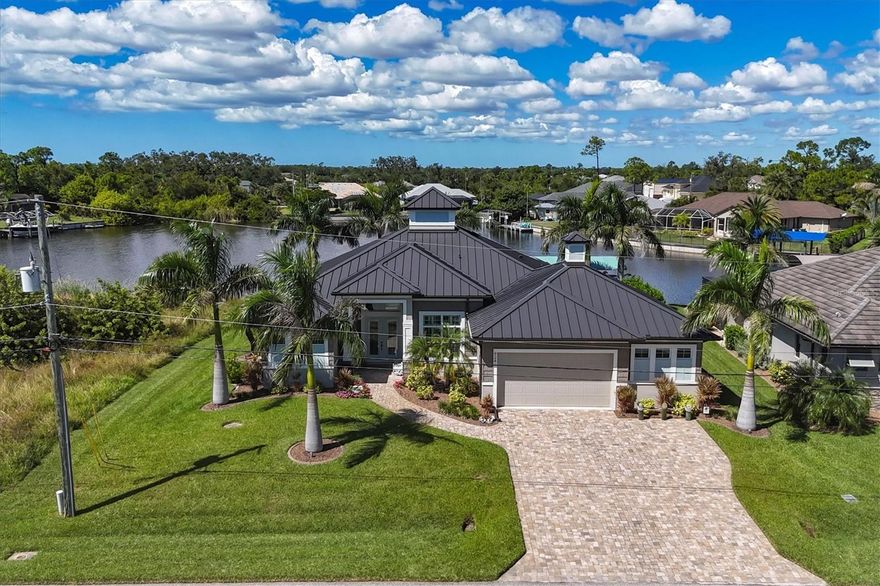 Exceptional 2017 coastal-style waterfront home in the highly desirable boating community of South Gulf Cove with direct access to the Gulf of Mexico. This stunning residence offers 2,128 sq. ft. under air with 3 bedrooms, 3 full baths, an office/den, and a 3-car garage, perfectly blending elegance, comfort, and craftsmanship. The open floor plan features diagonally laid ceramic plank tile, crown molding, plantation shutters, 8’ doors with custom trim, and wood-accented coffered ceilings. The chef’s kitchen is a showpiece, showcasing a 10’ granite island, stainless-steel appliances, induction cooktop, pot filler, glass tile backsplash, and custom cabinetry with pullouts. The wet bar includes granite counters, sink, wine refrigerator, and glass-front cabinetry, ideal for entertaining in style. Expansive 10', zero-corner sliders open to an oversized lanai featuring a floor-to-ceiling stone fireplace, granite outdoor bar with refrigerator and ice maker, and a heated saltwater pool complete with sun shelf, therapy jets, and LED lighting. The panoramic picture window, no-seeum screen enclosure perfectly frames breathtaking views across the 400-foot-wide Santa Cruz Waterway, offering unforgettable sunsets. Outdoor highlights include a sunken LP gas fire pit, 36' x 8' TREX composite dock with water and electric, 10,000 lb. covered boat lift, and a full seawall. Lush, pro-vista grass and tropical landscaping is maintained by an irrigation system that draws from the canal, no city water bill! Additional features include a new standing-seam metal roof with transferrable warranty, impact windows, generator hookup, security system, tongue-and-groove wood ceilings, and enclosed garage storage with golf cart door. Conveniently located halfway between Sarasota and Fort Myers, this home is minutes from world-class fishing, championship golf courses, two Major League Baseball spring training facilities, pristine Southwest Florida beaches, and an array of shopping and dining options. A perfect blend of luxury and livability, experience true coastal Florida living at its finest! Paradise awaits you!!!
