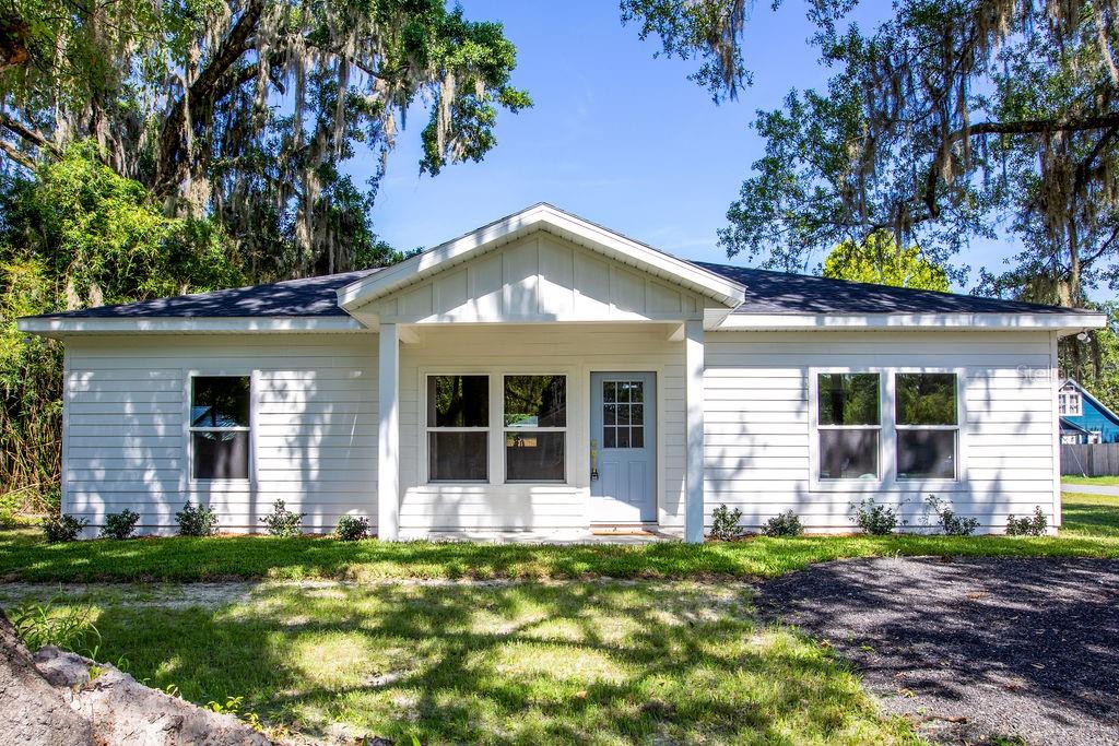 NEW CONSTRUCTION! Now priced WELL below market value for a quick sale! Nestled on a corner lot with picturesque Live Oaks, no detail was overlooked in creating this French country-inspired home. Designed with elegance in mind, the soft gold tones and warm textures set a serene, upscale ambiance immediately upon entry. Featuring elevated 9ft ceilings with a peaked 14ft vault, a designer lighting package, real wood two-toned cabinetry, quartz countertops in both the kitchen and bathrooms, stainless steel appliances, a walk-in pantry, and vinyl plank flooring + tile throughput (no carpet). The spacious owner's suite is a true retreat, complete with a tiled walk-in shower, dual sink vanity, two closets, and a masterfully connected wraparound laundry room configuration for ultimate convenience. The thoughtful floor plan maximizes every square foot, offering both open-concept living and a split-bedroom layout for privacy and comfort. Stepping outside, enjoy a generously sized backyard and concrete patio, ideal for entertaining, gardening, or simply soaking in the quiet surroundings. The prime corner lot allowed for a thoughtfully designed gravel circle drive to maximize parking, aesthetic appeal, and usability. All of this is just 5 minutes from the dining and shopping of Starke, 30 minutes to Gainesville, and 40 minutes to Jacksonville. This one truly couples luxury and convenience, all for the best price on the market. Call today to schedule your showing!