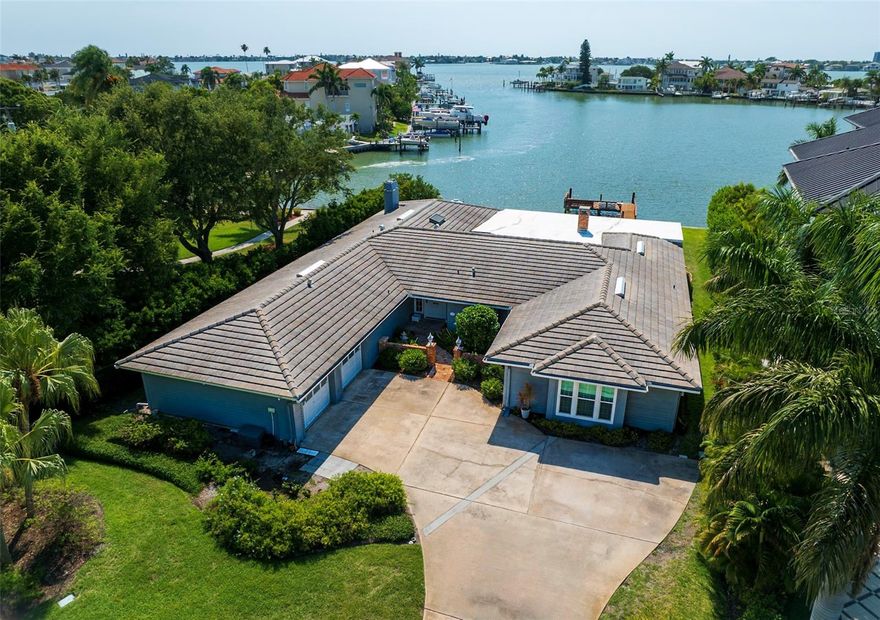 Welcome to this lovely and charming waterfront home located in the desirable town of Belleair. Situated on a 1/3 acre+ lot with 100 ft of waterfrontage, the residence offers open views of the intracoastal waterway over a private, protected dockage, and an exquisitely remodeled pool. Tastefully appointed, outstanding features include handsome moldings, coffered ceilings, expansive sliders that extend across the rear of the home offering cheerful, natural light and long views of the captivating waterfront.   A flexible floor plan has an extensive primary suite on one side of the home with the capability of having a dual bedroom or additional study and includes multiple closets and large bathroom area providing dual vanities and walk in shower. A spacious office or fourth bedroom is accessed from this area as well.  The living areas are graciously proportioned and situated next to the spacious, fully equipped kitchen providing the perfect flow for entertaining or more casual family enjoyment. Inviting breakfast nook and eat-in bar is perfectly situated to allow for easy daily living. The  impressive dining room is spacious offering the perfect area to entertain in style during the holidays or special occasions. Located on the opposite side from the primary suite, the floor plan includes two additional bedrooms with adjoining bath areas, and a separate access hall to several storage closets, and the generous sized laundry room. Wood burning fireplaces, attractive flooring, and over 4400 square foot to enjoy for those who require space, this is a very lovely property situated on one level for easy living for all ages in a location that is extraordinary; minutes to gorgeous beaches, fine dining, shopping, and private golf courses with outstanding social amenities. Major access roads to Tampa, airports and St. Pete are just minutes away. Don’t miss this Belleair gracious residence offering an unparalleled living experience that many dream of!