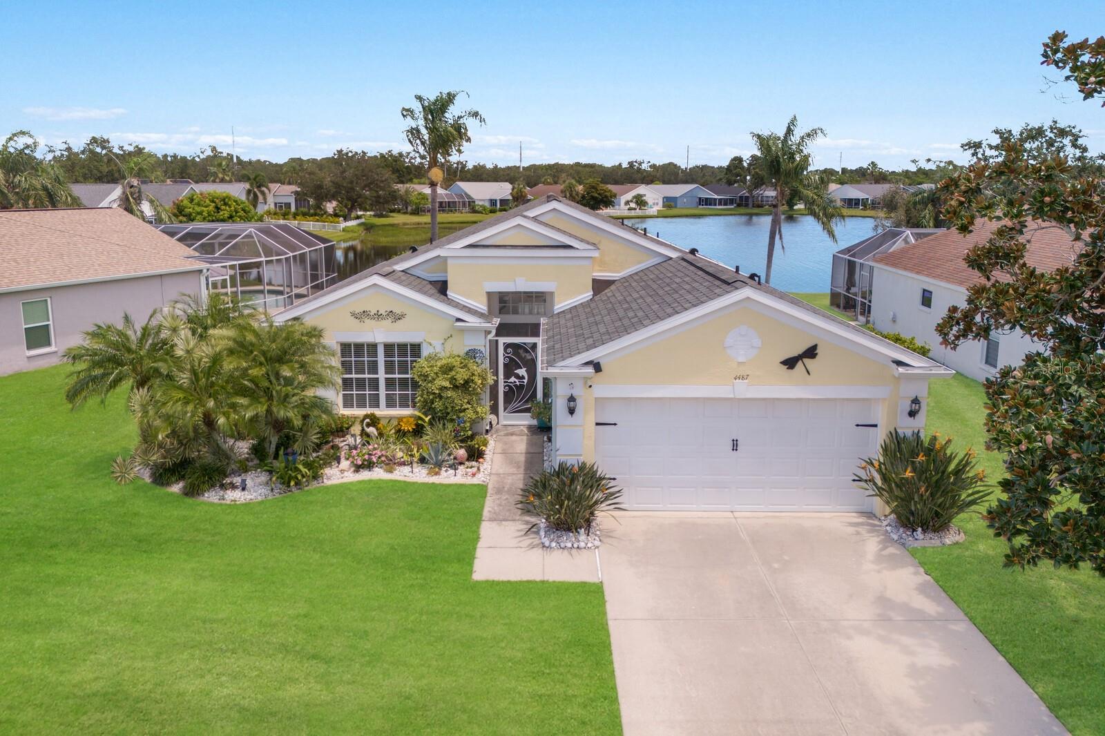 This charming coastal 4 bedroom, 2 bath pool home is beautifully maintained, move-in ready, and perfectly set on a gorgeous pond. With no CDD fees, you can relax in style and enjoy the true Florida lifestyle - with fewer costs and all the sunshine-filled moments you deserve! Lush tropical landscaping creates instant curb appeal, drawing you in from the moment you arrive. A screened front porch with a custom dolphin-design door sets the tone for this cheerful, sun-filled residence. Just off the entryway, a spacious bedroom with double-door entry offers the perfect flex space for a home office, den, or guest room. Step further in to discover a bright, airy great room with soaring cathedral ceilings, ideal for both formal dining and relaxed gatherings. Transom windows above both the front door and the sliders cascade natural light in these living areas. Your large kitchen is situated adjacent to the dining room and features an abundance of cabinets, gleaming stone counters, stainless appliances including smooth cooktop range, tile backsplash, & an eat-in café/kitchen nook for casual dining. Wide sliders off the gathering room open to create a gorgeous welcome to the stunning crown jewel of the home - your custom outdoor screen-enclosed oasis, complete with luxurious heated pool overlooking a beautiful pond. Entertain effortlessly with a NEWER (2023) Nebula LED lighting system that lets you set the mood via remote. Decorative stamped concrete on the lanai adds an elevated custom touch, and tropical landscaping around the pool provides extra privacy. Imagine dining al fresco under the covered lanai, enjoying the gentle breeze from the dual ceiling fans, while taking in the spectacular view! Back inside, just off the great room is your spacious Primary Retreat, with soaring vaulted ceiling & sliders that lead to the screened-in pool lanai. Your en-suite Primary Bath includes spacious angled extended vanity & dual sinks, stone counters, shower with glass shower door enclosure & decorative listello trim, walk-in closet, and private water closet. Two additional bedrooms on the opposite side of the home share a modern full bath with a sleek step-in shower that showcases floor-to-ceiling tile. A laundry closet with washer & dryer sits off the back of the kitchen for added convenience. Other notable upgrades to the home include BRAND NEW water heater (2025); NEWER exterior paint (2023); NEWER seamless rain gutters (2023); NEWER roof (2021); NEWER solar panel/blanket on roof to heat pool (2021); NEWER GE appliances in kitchen (2020); pool cage repainted and rescreened in 2020; NEWER lanai screen doors (2020); exterior security camera & video doorbell, and in-ground sprinkler system. EXCELLENT location in Sabal Harbour, with amenities including resort style pool; clubhouse; tennis, basketball & volleyball sports courts; and playground. Close to SR-70, 44th Ave, and I-75, with plenty of world-class shopping, dining, & entertainment nearby and only 30 minutes or less to gorgeous Gulf beaches like Anna Maria Island & Bradenton Beach!