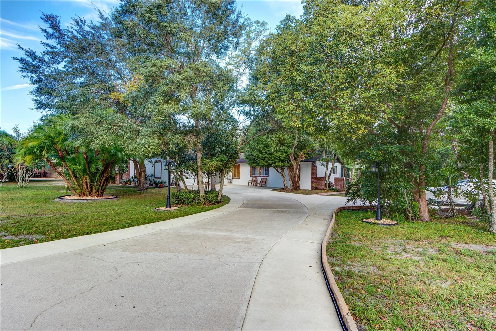 CHARMING 1 story craftsman bungalow block home on 3.42 acres THAT HAS BEEN LOVINGLY UPDATED! This home sits on a QUIET CUL-DE-SAC on a paved street in the Chuluota community of CHULA VISTA! No HOA! You will love this DOUBLE LOT with about 200’ of frontage, plus access to BASS LAKE. Feel like a quiet day fishing? Bass Lake offers a great opportunity to catch some large bass! PRIVACY awaits this owner as the home sits up close to the front of the lot with ACERAGE & WOODS behind the home & to the south of the home. In addition, the owner recently fenced both sides of the property. The spacious 27’ by 12’ screened back porch overlooks the tranquil backyard with a view of open land & trees - it is super relaxing to sit out back on the porch. Have a hobby or business needing extra storage and truck & trailer parking? This owner recently put in a LARGE STORAGE SHED in the back of the property! Brand new electrical panels & breakers including the 2 boxes for the HVAC system. Brand new hot water heater. New septic pump & septic system + well/water system were recently inspected. AS YOU DRIVE UP TO THE PROPERTY, YOU WILL LOVE THE FRESH LANDSCAPING, BRAND NEW EXTENSIVE CONCRETE DRIVEWAY, which was recently enlarged, & CUSTOM QUALITY EXTERIOR PAINT JOB WITH A NEW GUTTER SYSTEM GIVING THE HOME A LATIN ARCHITECTURAL FLARE! Enter the NEW FRONT DOOR & BE GREETED BY THE BEAUTIFUL LIFEPROOF WATER RESISTANT VINYL PLANK FLOORING throughout the home except bathroom 2. Fresh light gray paint greets you throughout the entire home. All the popcorn ceilings have been removed & replaced with 2 LAYERS OF JOINT COMPOUND FOR THAT SMOOTH CRAFTSMAN CEILING LOOK! GORGEOUS NEW SLIDERS FRAME BOTH THE FAMILY & DINING ROOM AREAS for a panoramic view of the property. THE SPECTACULAR & COZY KITCHEN AREA offers solid white painted wood cabinet boxes with new white shaker doors & stainless-steel knobs. The entire kitchen was recently remodeled. The new white & gray solid surface countertops offer richness but low maintenance. The finishing touch is the tumbled marble stone backsplash & newer stainless-steel appliances and a farmhouse sink. The stainless-steel vent over the cooktop is vented through the attic to the outside. All NEW INTERIOR DOORS, INCLUDING CLOSET DOORS, give this home a fresh new look! BOTH BATHROOMS HAVE BEEN UPDATED. BATHROOM 2 has all new modern tiles in the shower & on the floor with new vanity & toilet. You will love this 1567 ht. sq. ft. home (measured by an appraiser) with 2281 total square feet (1567 sq. ft. home + 330' sq. ft. garage + 27' x 22' sq. ft. back porch + 12' x 5' sq. ft. front porch- all measured by an appraiser). The home has 3 bedrooms and 2 bathrooms & it shows the recent, quality updated work! There is plenty of room to add another building and/or a garage (including an RV garage) on this land. This property includes the back canal that goes into Bass Lake, & it includes walking access to the lake. You own lake access to Bass Lake via owning the canal & the land on each side of the canal - this is clearly marked for your convenience when you walk the property. You are minutes from Oviedo with all its yearly events, shops, restaurants, parks, & trails! Tourist attractions & beaches are about an hour away! Zoned for top rated public schools. For someone who wants privacy, land, access to a fishing lake, & a place to put a boat and/or a trailer(s) and/or a RV and/or a truck(s), then this is central Florida living at its best!