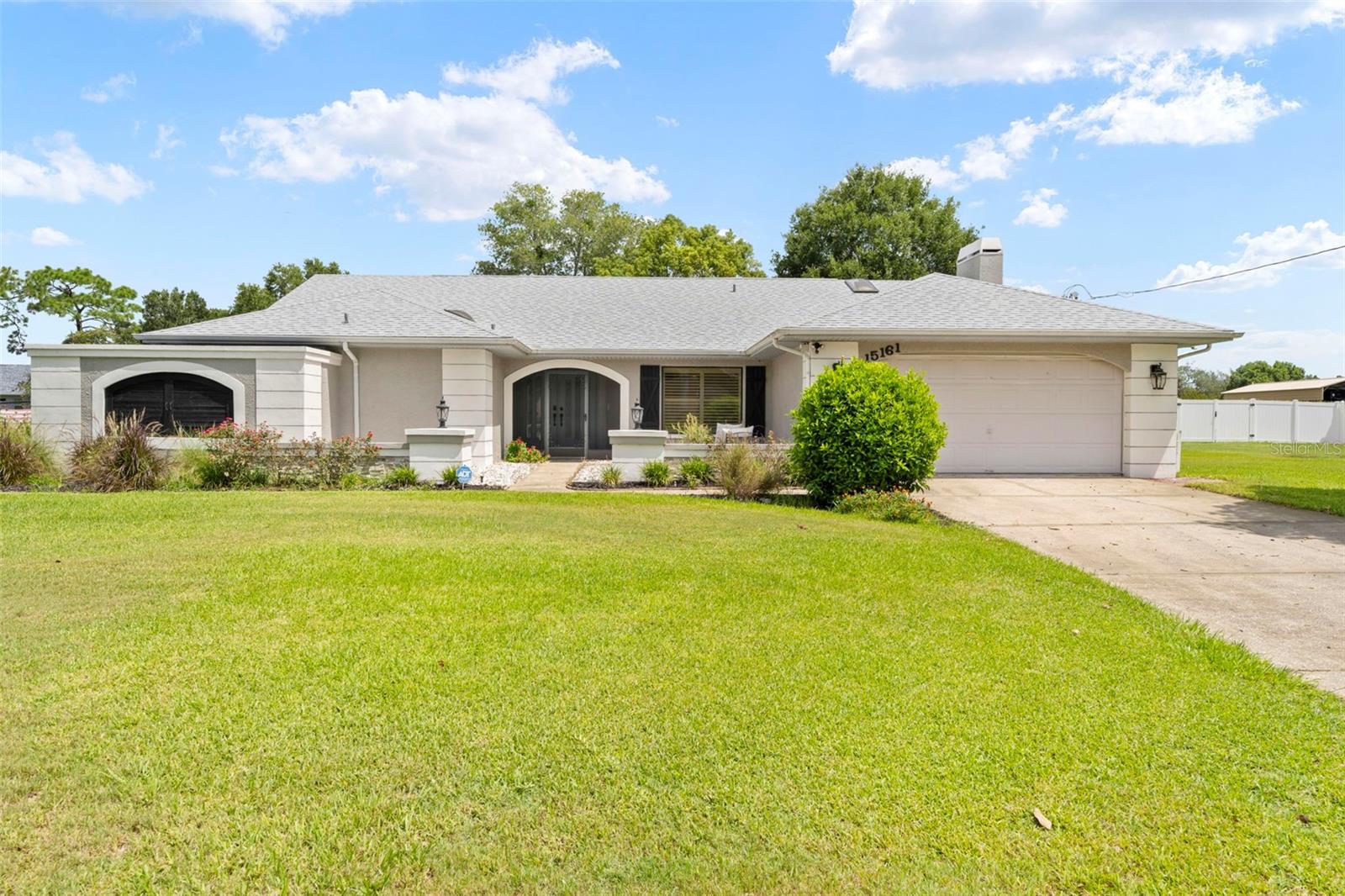 Welcome to Woodbury Road, where comfort, charm, and thoughtful updates come together in this beautifully maintained 3-bedroom, 2.5-bathroom pool home with a 2-car garage and 2,012 square feet of living space. Enjoy peace of mind with a new roof installed in 2022 and a layout designed for both relaxation and entertaining.
As you enter through the double door entry, you're welcomed into a spacious living and dining room combination, with the formal dining area to the right—perfect for hosting gatherings. The living room features sliding glass doors that provide an immediate and inviting view of the screened-in pool area, setting the tone for the Florida lifestyle from the moment you step inside. This home is adorned with elegant plantation shutters throughout, including on the sliding glass doors, offering both style and privacy.
To the left of the living room is the master suite, a private retreat featuring sliding glass doors to the lanai, plantation shutters, walk-in closets, and a luxurious en suite bathroom. The master bath boasts dual sinks with stone countertops, wooden cabinetry, tile flooring, a fully tiled walk-in shower, and a relaxing sunken garden tub.
At the heart of the home is a well-appointed kitchen showcasing solid wood cabinetry, granite countertops, stainless steel appliances, and tile flooring. A breakfast bar with seating for three opens directly to the cozy family room, which features a beautiful fireplace and plush carpeted flooring—an ideal space for casual gatherings. Sliding glass doors from both the kitchen and family room lead out to the covered lanai, offering a seamless indoor-outdoor flow.
The lanai features an in-ground pool with a full pool cage, cabinetry with a sink, and electrical hookups ready for a future cooktop. Just beyond the screened lanai, you'll find a paver patio with a hot tub, perfect for relaxing evenings.
Just off the family room, a hallway leads to the guest bathroom, located on the left, offering direct access to the pool. This bathroom has been tastefully updated with a dual sink wooden vanity, tile flooring, and a walk-in tiled shower with sliding glass doors. Across the hall, the indoor laundry room includes a deep sink, storage cabinetry, and a commode for added convenience.
Further down the hall is the second guest bedroom with a standard closet, carpeted flooring, and pocket doors that open into the third bedroom, which features its own standard closet and sliding glass doors to the pool. This unique layout offers the flexibility to combine both rooms into one large suite or spacious bedroom—perfect for guests, multigenerational living, or a home office.
Additional highlights include a well for irrigation, roll-up hurricane shutters for peace of mind, and mature landscaping surrounding the home. Located in Spring Wood Estates, this property places you just minutes from the Suncoast Parkway (589) and close to most major shopping, including Target, Kohl’s, Publix, and so much more.
This home offers the perfect blend of privacy, functionality, and Florida lifestyle—set your appointment today!