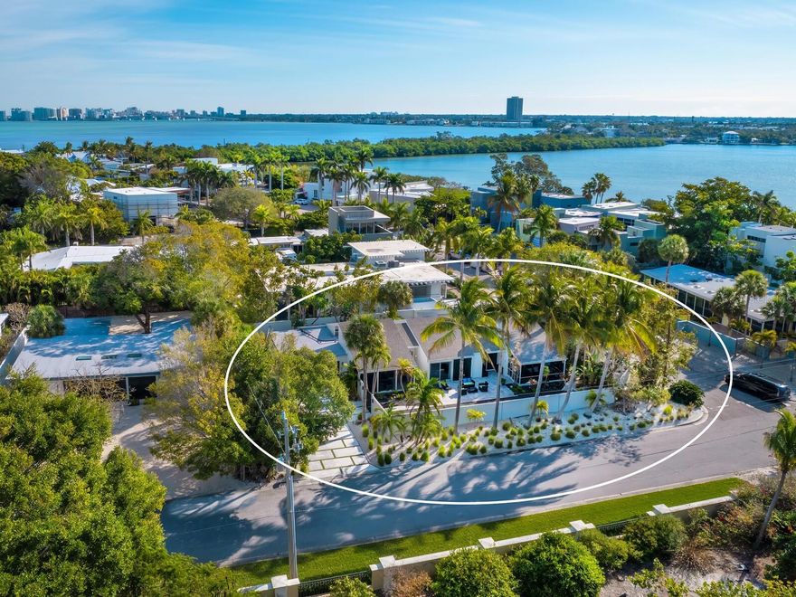 Welcome to 1100 Westway Drive, an exquisite example of modern architecture and design, in one of the area’s most desired locations in the sought-after Lido Shores neighborhood. Near the entrance to a private beach, this fully renovated residence and its grounds epitomize the Florida coastal lifestyle. Enter the gates of this ultra-private, spa-like retreat through the courtyard door and you will feel like you are in your paradise. You are greeted by the striking beauty of a heated 60-foot lap pool under a canopy of palms, setting the tone for a home that is a retreat and a place for gathering. Featured in the Sarasota Architecture MOD showcase, each space within this residence has been thoughtfully designed to blend luxury with functionality. The heart of the home is the spacious living area with high ceilings and windows throughout, inviting an abundance of natural light to flood the interior. The sleek, state-of-the-art kitchen features custom cabinetry, wine refrigerator, oversize island and elegant stone countertops making this a chef and entertainer’s delight. The primary suite is a sanctuary of peace and luxury, offering a private screened-in porch with views of the courtyard, a spacious layout with custom built-ins, fireplace and an en-suite bath with soaking tub and walk-in shower. Each additional bedroom is spacious and thoughtfully appointed, with large closets and doors that open to tropical porches or patios for gulf breezes and relaxation and serve as private entrances. The home features 4 bedrooms plus an office (with closet) that can be an additional bedroom. The walled property also features an outdoor shower, travertine patio off the dining room for outdoor grilling, landscape lighting throughout, a fishpond and fountain, and views of the lush tropical landscaping from every room in the home. The expansive outdoor space is an extension of the home offering the ultimate in indoor/outdoor lifestyle. The private beach access that is nearby also features a gazebo for entertaining and enjoyment with stunning views of the blue waters of New Pass and the Gulf of Mexico. Just minutes from St Armand's Circle, Longboat Key and downtown Sarasota, this is your paradise in the middle of it all!