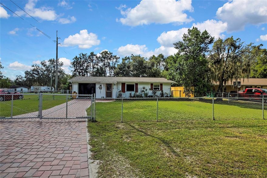 Welcome to this delightful 2-bedroom, 1-bathroom home located in the vibrant community of Floral City, Florida. This inviting property has been thoroughly updated, featuring a new roof, septic system, and air conditioning, all installed in 2021, which promises a hassle-free living experience. Inside, you will find a newly designed kitchen equipped with soft-close cabinets, butcher block countertops, newer refrigerator w/reverse osmosis, new disposal, wood-look plank tile throughout, alongside a modernized bathroom that boasts a new walk-in shower, completed in 2025. Recent enhancements, also from 2024/2025, include an impressive 100 feet of stockade fencing, additional chain link fencing around the property, a motorized gate with ghost remote, a paver driveway, a motorized garage screen, utility sink in garage, front screen door and electric setup with lights and outlets in both the shed and chicken coop. The screened lanai offers a serene view of the beautiful private backyard, which features a newer shed, chicken coop, and raised garden beds. The addition of a new gutter system and beautifully landscaped yard further enhances the home's functionality and curb appeal.  For those into Nature-friendly outdoor recreation like birding, boating, picnicking, canoeing, hiking, fishing, inline skating, bicycling, hunting, camping and equestrian pursuits, you will find miles and miles of trails at the nearby Flying Eagle Wildlife Park, Ft. Cooper State Park and the Withlacoochee State Forest Park.  Seize the opportunity to make this charming home your own—contact me today to schedule a viewing!!