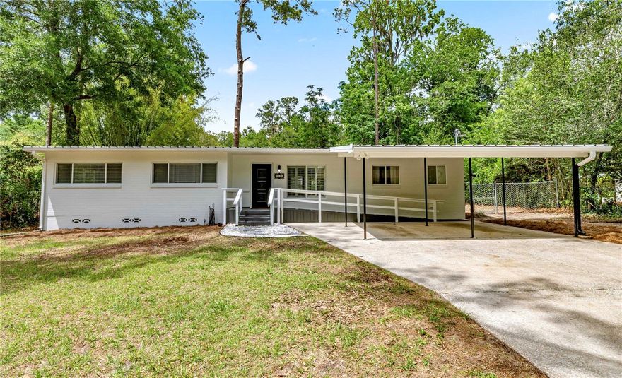 Welcome home to this beautifully updated 3-bedroom, 2-bath block residence in the highly sought-after Mason Manor community, ideally located less than two miles from the University of Florida and just moments from premier parks, dining, shopping, and Gainesville’s top medical centers, including UF Health Shands Hospital and the Malcom Randall VA Medical Center. Known for its established charm and exceptional central location, Mason Manor offers a lifestyle of convenience with easy access to schools, work, nature trails, and everyday amenities, along with the added ability to walk to your favorite sporting events at Ben Hill Griffin Stadium. Thoughtfully enhanced with approximately $30,000 in recent improvements, this move-in-ready home blends timeless character with meaningful modern upgrades. Natural light pours throughout the spacious open-concept layout, where the living, dining, and flex spaces flow seamlessly together for both everyday living and entertaining. Oversized double-pane windows, elegant plantation shutters in the main living areas, blinds elsewhere, and warm finishes create a bright and welcoming atmosphere throughout the home. The kitchen combines style and function with quartz countertops, Whirlpool appliances, and timeless flat-panel mid-century styled cabinetry that adds warmth, charm, and character. Interior features include real oak hardwood flooring, terrazzo accents, tile flooring, 2” faux wood blinds, updated lighting, and a spacious indoor laundry/utility room with additional storage and private side-entry access. Recent upgrades completed in 2026 include fresh interior and exterior paint, professional pressure washing, professionally deep cleaned flooring surfaces and tiles, updated lighting and added recessed can lights, a new Whirlpool glass cooktop, new locks, added smoke and carbon monoxide detectors, updated ceiling fans, new bifold closet doors, and a brand-new water heater. Additional major system improvements include a full HVAC replacement and electrical panel upgrade completed in 2023, along with a durable metal roof installed in 2009. Both bathrooms have been beautifully renovated with quality tile work, updated cabinetry, and solid granite countertops, offering a clean and elevated feel. Outside, the expansive .29-acre lot features a fully fenced backyard with extra-tall chain-link fencing, and a large side fence opening designed for convenient boat or trailer access and storage. Additional exterior features include gutters, fresh landscaping, and a large powered storage shed ideal for a workshop, home office, gym, or creative studio. A double carport and extended paved driveway provide ample parking space for guests, recreational vehicles, or additional toys. Nature lovers will appreciate being just moments from Loblolly Woods Nature Park, a scenic 159-acre preserve with walking trails and boardwalks, while the home’s central location places you close to everything Gainesville. Offering a rare combination of location, upgrades, charm, and functionality, this exceptional Mason Manor residence is the perfect place to call home. Location, location, location!