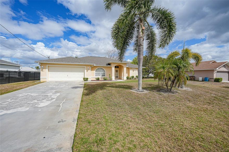 Welcome to this well-maintained 1,785-square-foot home in the highly desirable Jacarandas neighborhood of Cape Coral. This 3-bedroom, 2.5-bath residence combines comfortable Florida living with attractive curb appeal and a spacious, open layout. The light, neutral exterior is complemented by mature palm trees, creating a welcoming first impression. A generous driveway leads to the two-car garage, offering ample parking and convenience, while a covered front entry with an elegant arched window invites you inside. Step into the beautifully designed living and dining area, where high ceilings, crown molding, and neutral tile flooring create an open, airy atmosphere. Corner sliding glass doors in both the living room and family room open directly to the expansive 24×16 screened lanai, complete with a relaxing hot tub and a convenient half bath. This space creates seamless indoor/outdoor living, perfect for entertaining or relaxing. The large backyard offers plenty of room to fence the yard and even add a pool, providing endless possibilities for outdoor enjoyment. The bright, spacious kitchen overlooks the family room, creating a natural connection for everyday living and entertaining. Vaulted ceilings make the space feel expansive, while crisp white cabinetry provides abundant storage and a timeless look. Warm, neutral countertops complement the tile backsplash, featuring earthy beige and tan accents for subtle texture and visual interest. A stainless-steel appliance suite—including a side-by-side refrigerator, built-in microwave, dishwasher, and electric range—adds a modern touch. The peninsula-style counter offers bar seating for three, providing a convenient spot for casual meals or conversation, while raised-panel cabinetry throughout enhances the classic, upscale feel and ensures exceptional storage.  Off the kitchen, the laundry room includes a washer, dryer, and utility sink, and provides direct access to the two-car garage for convenience and functionality. The primary suite is a private retreat, featuring wood laminate flooring, a dramatic tray ceiling, and direct access to the lanai. It includes a spacious walk-in closet and an ensuite bath with his-and-hers vanities, a large walk-in shower, and a relaxing soaking tub. Guest bedrooms are generously sized with built-in closets and easy access to a full bathroom, while the third bedroom offers versatile use as a den, home office, or additional living space. Additional features include a roof installed in 2020, A/C from 2019, solar panels, hurricane protection, and a water treatment system, ensuring comfort, efficiency, and peace of mind. This home is within half hour drive to some of Florida best Gulf Coast Beaches, schools, shopping, restaurants and roads like Del Prado Blvd and US-41.
**PLEASE ENJOY THE 3D INTERACTIVE VIRTUAL TOUR ASSOCIATED WITH THIS LISTING**