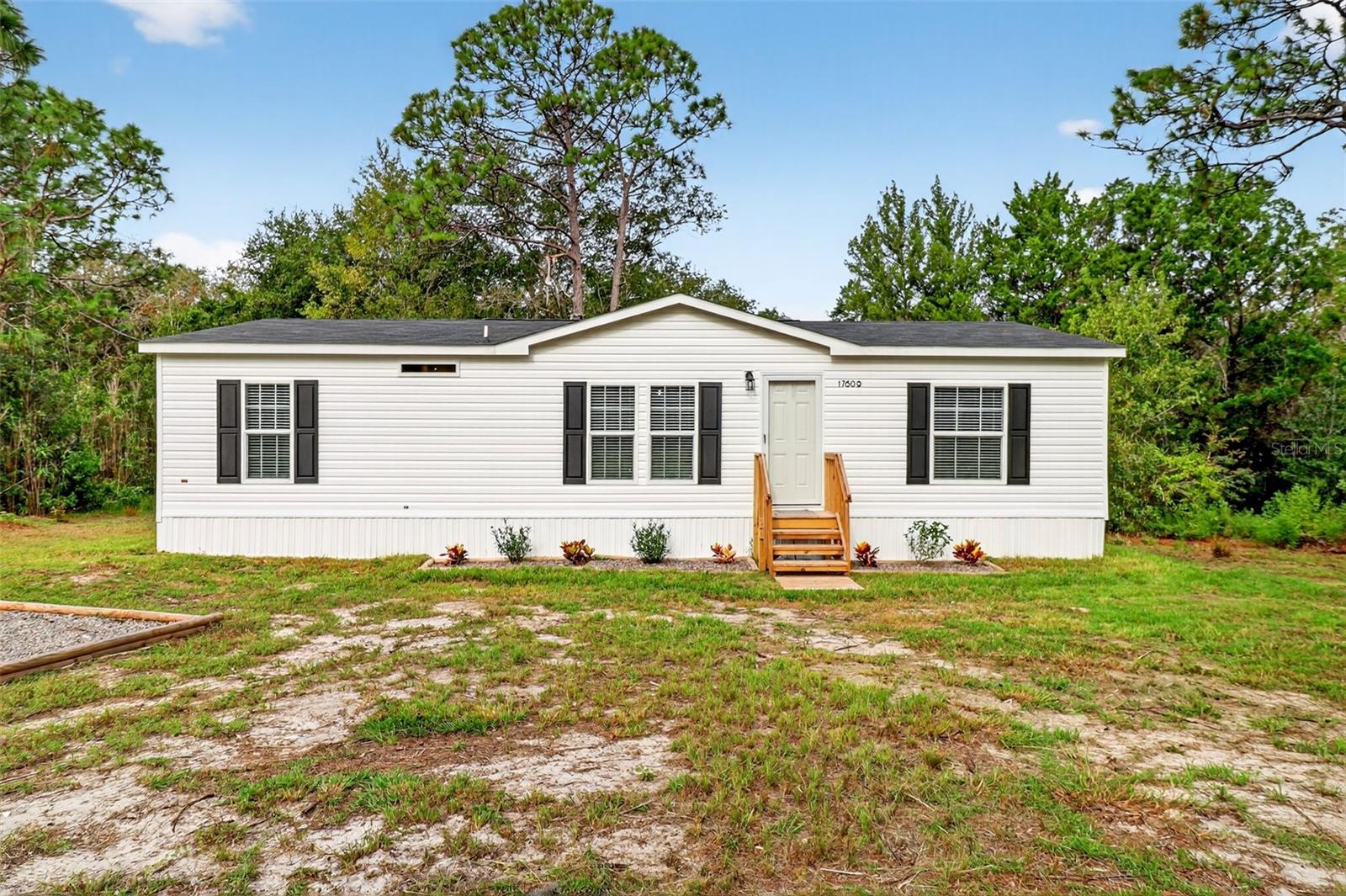 WOW!! Stunning, NEW 2024-build 3 bedroom/2 bathroom manufactured home with modern and tasteful finishing touches, situated on 1.1 ACRES of land with NO HOA or lot rent, and AR zoning so you can bring all your toys from ATVs to RVs and family pets- big or small!! The large, blank canvas of a yard is ready for your personal touches to create your dream outdoor space. Inside you'll find an open layout with a split floor plan, vinyl flooring in all living spaces and plush, clean carpet in the bedrooms. Sleek new fixtures throughout, such as ceiling fans, lights and more. Beautiful kitchen has never-used cabinets and countertops, brand-new stainless steel appliances and a lovely island with barstool seating. Spacious masterbedroom features an ensuite with a separate stand-in shower and soaking tub, dual sink vanity AND walk-in closet. Purchase this home stress free without having to worry about needing a NEW roof, HVAC or septic/drainfeild anytime soon since they are ALL NEW! Schedule a showing now!