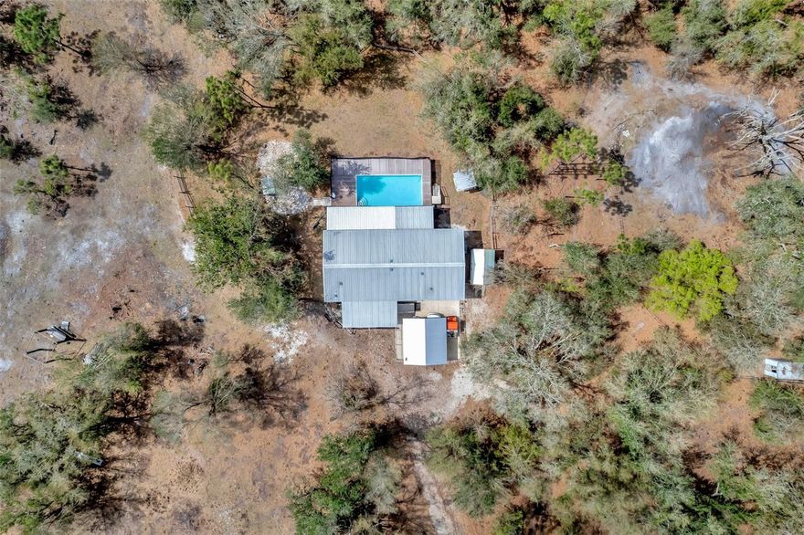 Preferred Lender is offering 1% of the loan amount as a lender credit towards buyers closing costs or interest rate buydowns on this specific home! Welcome to this stunning 3-bedroom, 2-bathroom pool home featuring a bonus room and a built-in tiki hut, constructed in 2016. Nestled on 10 acres of land, this property includes a spacious 3,000 sq. ft. workshop and the potential to build a guest home. Positioned well off the road, it offers seclusion and privacy. The property is equipped with a 60-kilowatt generator, two wells, and two septic tanks. Enjoy outdoor activities such as raising farm animals and ATV riding right on your land. As you enter the home, you will be greeted by a split open floor plan that includes a large kitchen with a pantry and a built-in bar area in the bonus room, perfect for entertaining. The HVAC system was replaced in 2023, and the water heater was recently updated in 2025. Don't miss the chance to own this exceptional property!