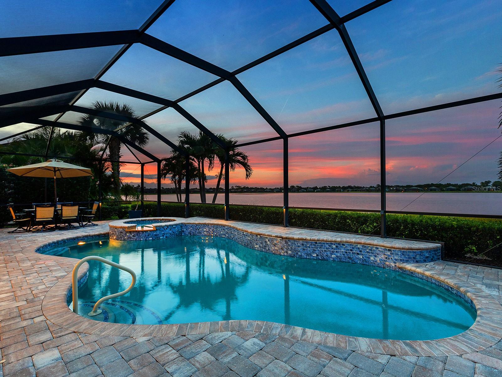 Superior location and amazing lake views are within reach! Shoreview offers an unbelievable location just 0.5 miles from Waterside at Lakewood Ranch with shopping, dining, park, and community events all within walking distance of your lakeside home. Boasting an impressive 66’ of lakefront views, this 2018 dual level Pinnacle floor plan by Pulte Homes offers a spacious, open floor plan with flexible spaces for every lifestyle. Enjoy enhanced privacy with a greenbelt and walking trail across the street with no neighbors outside your front door. Inside you will be impressed with porcelain wood-look plank tile flooring, crown molding, a neutral color palette, plantation shutters, and the peace-of-mind of having 2025 IMPACT windows. In the open floor plan, disappearing corner pocketing sliding glass doors highlight the lake view no matter if you’re in the spacious great room, upgraded kitchen, or dining room with designer chandelier. The seamless indoor and outdoor experience is enhanced by a large covered entertaining area with oversized ceiling fan, 2020 motorized hurricane and shade screen, and 2019 lights integrated into the pool cage. Whether it’s a sunny Florida afternoon or a romantic twilight sunset, the heated saltwater pool and spa will be your favorite place to relax and take in the lake views with additional privacy hedges around the lanai for your own private escape. The upgraded kitchen is smartly designed with a central island with counter-height seating and designer pendant lighting, crisp white cabinetry with molding, stone counters, glass mosaic tile backsplash, 2023 Kinetico water filtration and reverse osmosis, and walk-in pantry. The 2018 stainless steel KitchenAid appliance suite makes cooking meals a delight with gas cooktop and double wall ovens, plus enjoy an upgrade to a 2022 Bosch french door refrigerator. Enjoy the lake views from the moment you wake up in the primary suite with tray ceiling, plus en-suite primary bathroom featuring an oversized walk-in closet with custom shelving, dual sinks, stone counters, and upgraded walk-in shower with porcelain tile and built-in bench. Working from home is a delight in the private study with double doors. Guests can enjoy equal luxury on the main level in two guest bedrooms both with walk-in closets, and two full guest bathrooms; or relish in additional privacy in the oversized guest bedroom and full bathroom on the second level. The upper story also has a massive bonus room with endless potential as a fitness room, office, media room, play room, or anything your lifestyle desires. The laundry room doubles as a mudroom with extra cabinetry and counterspace. The 3-car garage is spacious and includes 2021 epoxy flooring and custom storage shelving. Peace of mind is secured with 2025 impact windows, 2025 rain gutters, 2025 smoke and carbon monoxide detectors, and 2023 Kinetico whole-house water softener. Shoreview at Waterside features 144 acres of lakes, clubhouse with gathering space, kayak launch, beach area, lighted tennis and pickleball courts, events lawn, and fitness center. Located just minutes from Waterside you are a short distance of shopping, dining, farmers market, parks, events, and more, while maintaining proximity to all Sarasota has to offer including world-class beaches. Lakewood Ranch is the top multi-generational community in the country for 7 years in a row!