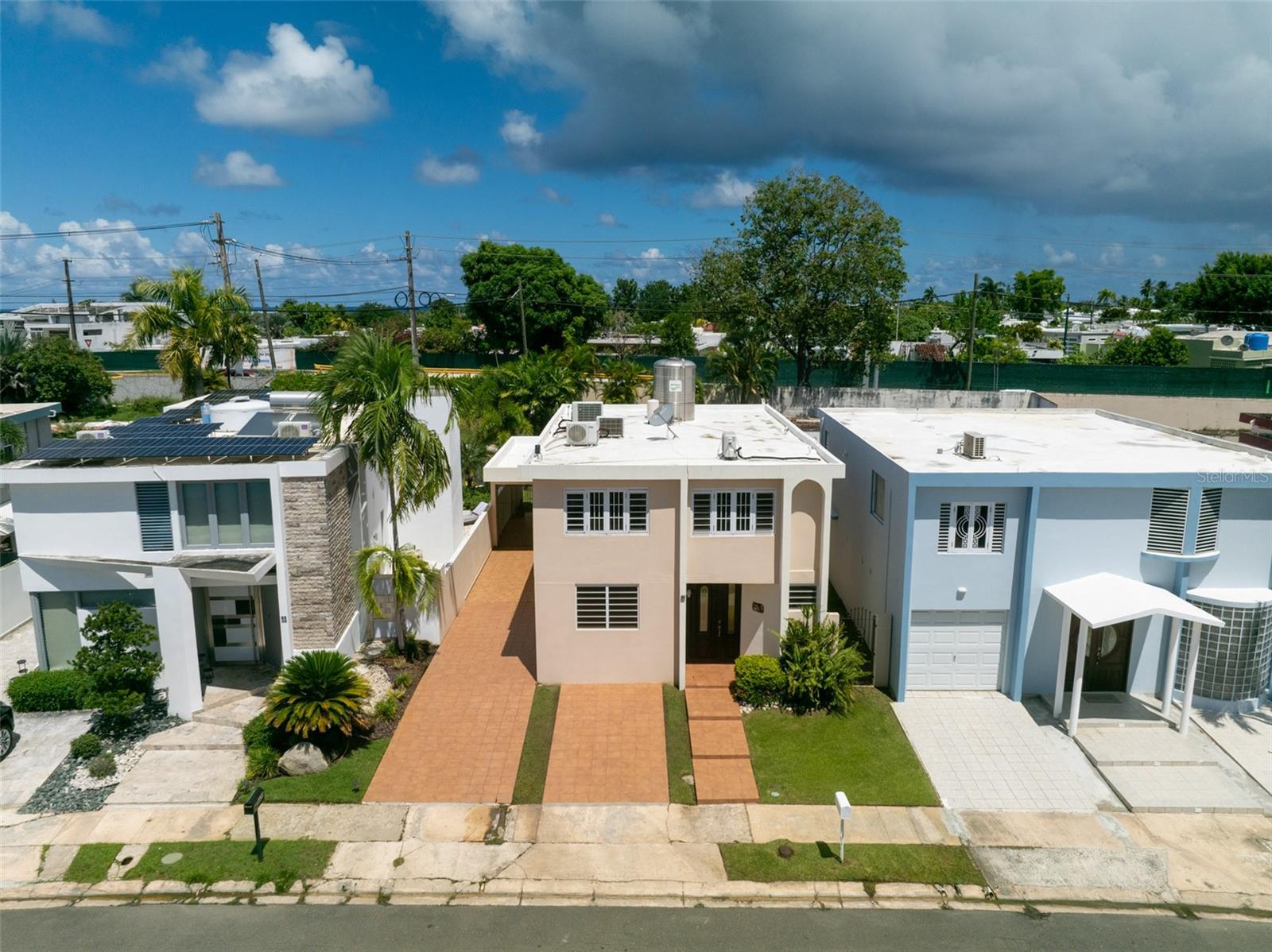 Discover this well-maintained two-story home featuring 4 bedrooms and 2.5 bathrooms, complete with a one-car garage and an additional four parking spaces. This property includes a storage room on the terrace, a 780-gallon water cistern with a pump, five ceiling fans, an electric water heater, and six mini-split A/C units. All window treatments and lighting fixtures are included. Ideally located near pharmacies, shopping malls, and supermarkets, and just 5 minutes from the beach, this home offers the perfect blend of comfort and convenience.
