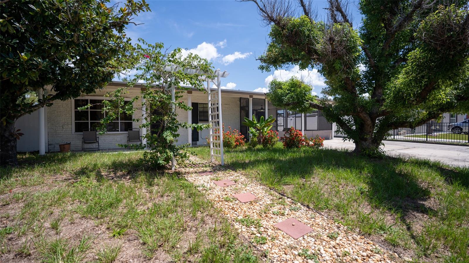 Centrally located in the heart of Town 'n' Country and just under 10 minutes from Tampa International Airport, this charming home is in flood zone X and does NOT require flood insurance—offering peace of mind and added value. Featuring 3 spacious bedrooms and 2 full bathrooms, plus a detached 450 sf In-Law Suite with a studio-style open layout, this property is perfect for multi-generational living, extended guests, or anyone in need of flexible space. One of the bedrooms in the main home can easily be converted into a second in-law suite, complete with its own exterior entrance, private bathroom, and small kitchen area. The inviting front porch with a sitting area welcomes you in, while the expansive screened-in lanai and fully fenced yard with PVC fencing create a private outdoor retreat. Inside, you’ll find plenty of closet storage and a layout designed for comfortable living. A large driveway offers ample parking, making this home as practical as it is charming. Don’t miss your chance to own this versatile property in one of Tampa’s most convenient and desirable locations!