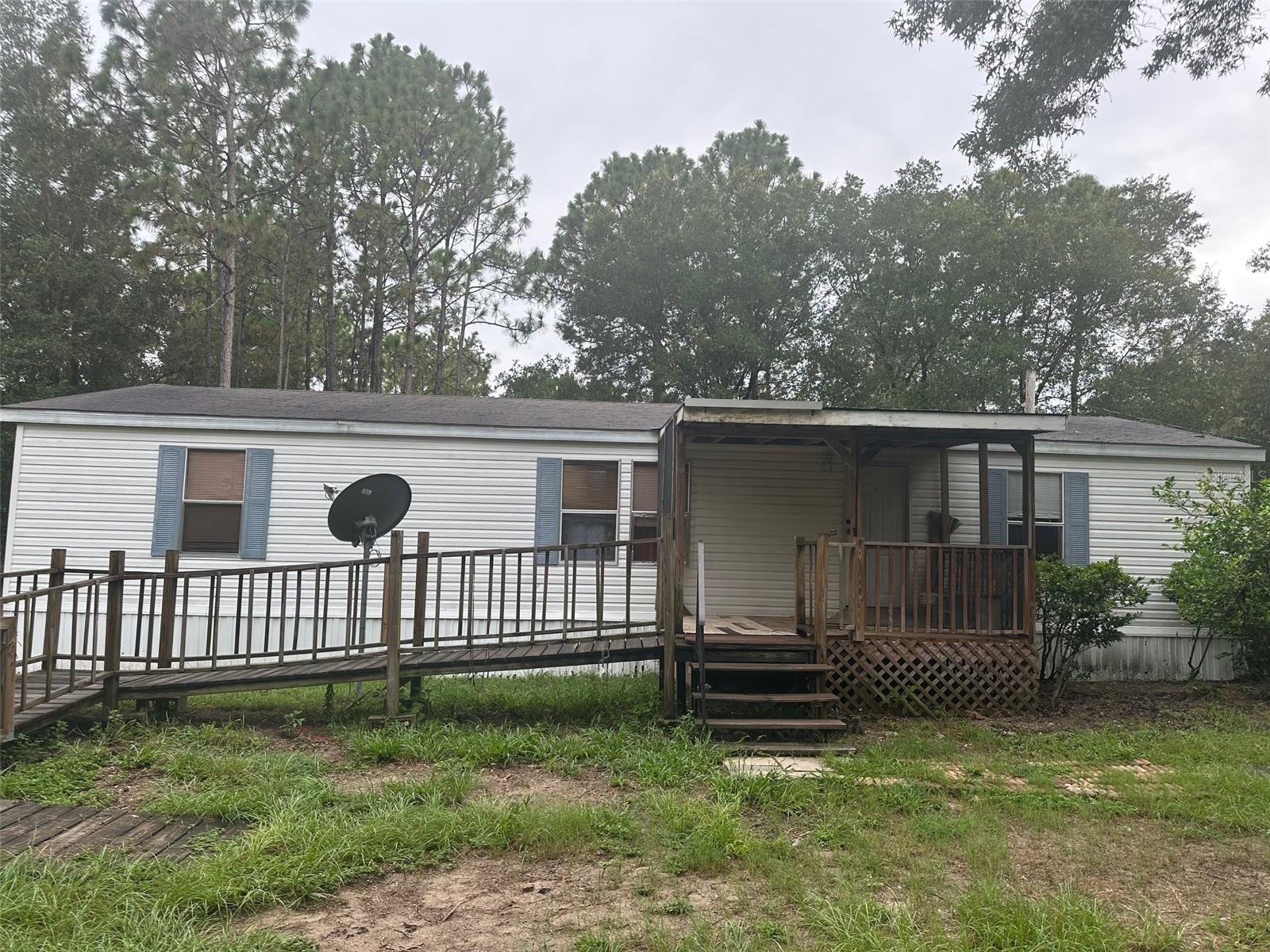This 1248 sq.ft. 3 bedroom, 2 bath home is nestled on a wooded 2.5+ acre parcel and is ready for your horses, pets, and toys! The split floor plan home boasts a main bedroom en-suite with shower & garden tub, a cathedral ceiling, breakfast bar, front ramp, and inside laundry area (washer and dryer DO convey). The property comes equipped with some perimeter fencing, a smaller fenced area, two storage sheds, and is situated in an X flood zone even though it's only a short drive away (about 10 min) from Crystal River. No HOA fees or regulations! Call today to schedule your personalized tour!