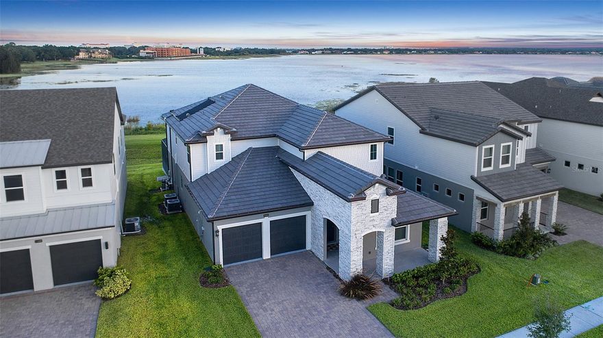 Move-in ready lakefront pool home in the sought-after Sand Lake Sound community, located in the heart of Dr. Phillips. This fully furnished, nearly new 5-bedroom, 3.5-bath residence was only briefly occupied and showcases an open-concept design with a chef’s kitchen, stainless steel appliances, oversized island, and seamless flow into the family room overlooking Big Sand Lake. The primary suite on the first floor includes a spacious bathroom with double vanities, soaking tub, and a large walk-in closet. Upstairs offers multiple bedrooms and a versatile loft space ideal for guests, family, or office use. Enjoy evening skyline views featuring the Orlando Eye. Built with energy-efficient features and smart-home technology, this home blends convenience with comfort. Sand Lake Sound is a gated community close to Restaurant Row, Dr. Phillips Hospital, Whole Foods, Trader Joe’s, Publix, major highways, and Orlando’s world-class theme parks. Zoned for highly rated schools.