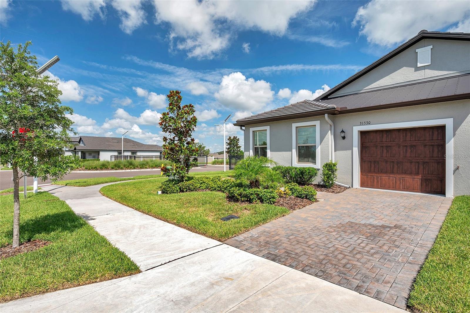 Maintenance-Free Villa in Gated 55+ Medley at Mirada! Welcome to this move-in ready end-unit villa in the highly sought-after 55+ Medley at Mirada community in San Antonio, Florida. This thoughtfully designed home offers 2 bedrooms, 2 full bathrooms, a versatile flex room, and a 1-car garage, all nestled in a gated, maintenance-free neighborhood with exceptional amenities. Step inside to an inviting open floor plan with a split-bedroom layout that maximizes privacy and functionality. You’ll find upgraded tile flooring laid in a stylish 70/30 offset throughout the main living areas, and plush carpeting in the bedrooms for added comfort. Crown molding (5¼") adds a polished touch to the living room, dining area, primary bedroom, and kitchen. The spacious kitchen is a chef’s delight, featuring a center island, 42" upper cabinets, a walk-in pantry, and upgraded quartz countertops with a 5" backsplash, complemented by stainless steel appliances. The adjoining living and dining areas flow seamlessly to the covered patio, offering the perfect space to relax or entertain in your backyard retreat. The primary bedroom boasts a large walk-in closet and a luxurious en-suite bath with dual sinks, upgraded quartz countertops with 5" backsplash, and a generous walk-in shower. The second bedroom is ideal for guests and is served by a hall bath with extended counter space, upgraded finishes, and a walk-in shower. Additional highlights include an inside laundry room and a flex room (10' x 12’) that offers endless possibilities - perfect as a home office, craft room, library, or den. Residents of Medley at Mirada enjoy exclusive access to the Medley Club, featuring a resort-style pool, fitness center with yoga, clubhouse events, pickleball and tennis courts, bocce ball, shuffleboard, dog parks for both small and large pups, and scenic walking trails. There’s even a Tot Lot for the grandkids! And that’s just the beginning—residents also have access to the incredible Mirada Lagoon, a beach-style oasis with swimming, paddleboarding, floating pickleball, waterslides, cabanas, mixology classes, bingo nights, and so much more. Live the lifestyle you’ve been dreaming of—schedule your showing today!
