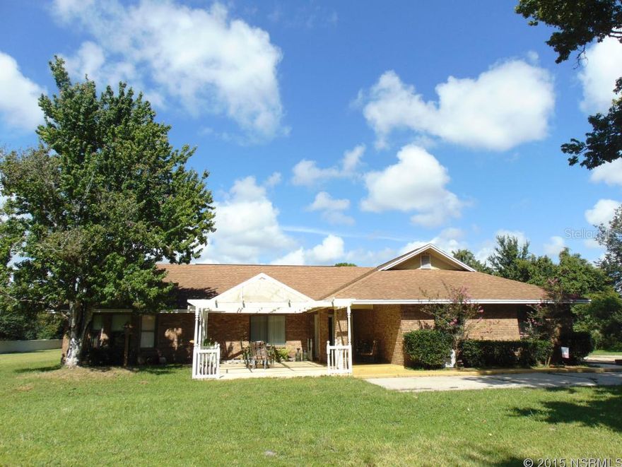 3BR+den, 3BA residence with front courtyard and patio, 3CG with extended driveway and outdoor parking nestled on 5 acres, partially wooded in rear. The home was custom when built. The split bedroom floor plan shows a foyer with coat closet, den of flex room ideal for a formal living, dining or home office. Zoned for Spruce Creek High School, Creekside Middle and Cypress Creek Elementary. There is a park across from the property to your leisure, walking and biking paths and several golf courses close by like Cypress Head, Spruce Creek Country Club and Venetian Bay golf club. The country style kitchen has a large breakfast counter and preparation area, buffet and many cabinets to store all your utensils. Open dining and sunken living room with fireplace highlighted with Cathedral and wood accent ceiling. All bedrooms have their own bath. The Master BR retreat has a sitting room, walk-in closet and a private bath with double vanity, walk-in shower and jetted tub. A set of sliding glass doors open to the backyard. The property has beautiful matured trees, a utility shed and outer building (not enclosed) with concrete slab and roof to park your mower. The property has lots of potential with its ideal location and fast access to New Smyrna Beach or Port Orange, shopping, schools and I-95. All measurements are approximate and the information is not guaranteed.