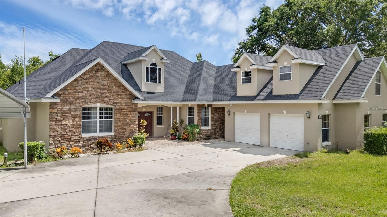Experience the perfect blend of space, privacy, and comfort in this custom-built estate home nestled on a sprawling 1.73-acre lot surrounded by mature trees and Florida’s natural beauty. This spacious home offers 4 bedrooms, 4.5 bathrooms, and 3,337 sq ft of thoughtfully designed living space. Step inside to discover a bright open-concept layout with high ceilings, a gourmet kitchen featuring stone countertops, stainless steel appliances, and an expansive layout that flows seamlessly into the living and dining areas—perfect for entertaining. The first-floor primary suite offers a peaceful retreat with spa-like comfort, while a large upstairs bonus room with its own private full bathroom provides flexible space for a media room, office, or guest suite. Enjoy outdoor living on the extended covered rear patio with a jacuzzi—ideal for relaxing evenings or weekend gatherings. Additional features include an oversized 2-car side-entry garage, a separate covered carport, a storage shed, and a private well and septic system. The lot is adorned with fruit trees and offers plenty of space to add a pool, garden, or simply enjoy the wooded surroundings. Roof replaced in 2022. Located off scenic Old Tavares Road, this home offers the tranquility of country-style living while being just minutes from downtown Leesburg, Tavares, and the Harris Chain of Lakes—a haven for boating, fishing, and water recreation. With its rich history, charming festivals, and growing amenities, this area is one of Lake County’s best-kept secrets. Don’t miss your chance to own this private custom home in one of Central Florida’s most desirable and scenic communities.