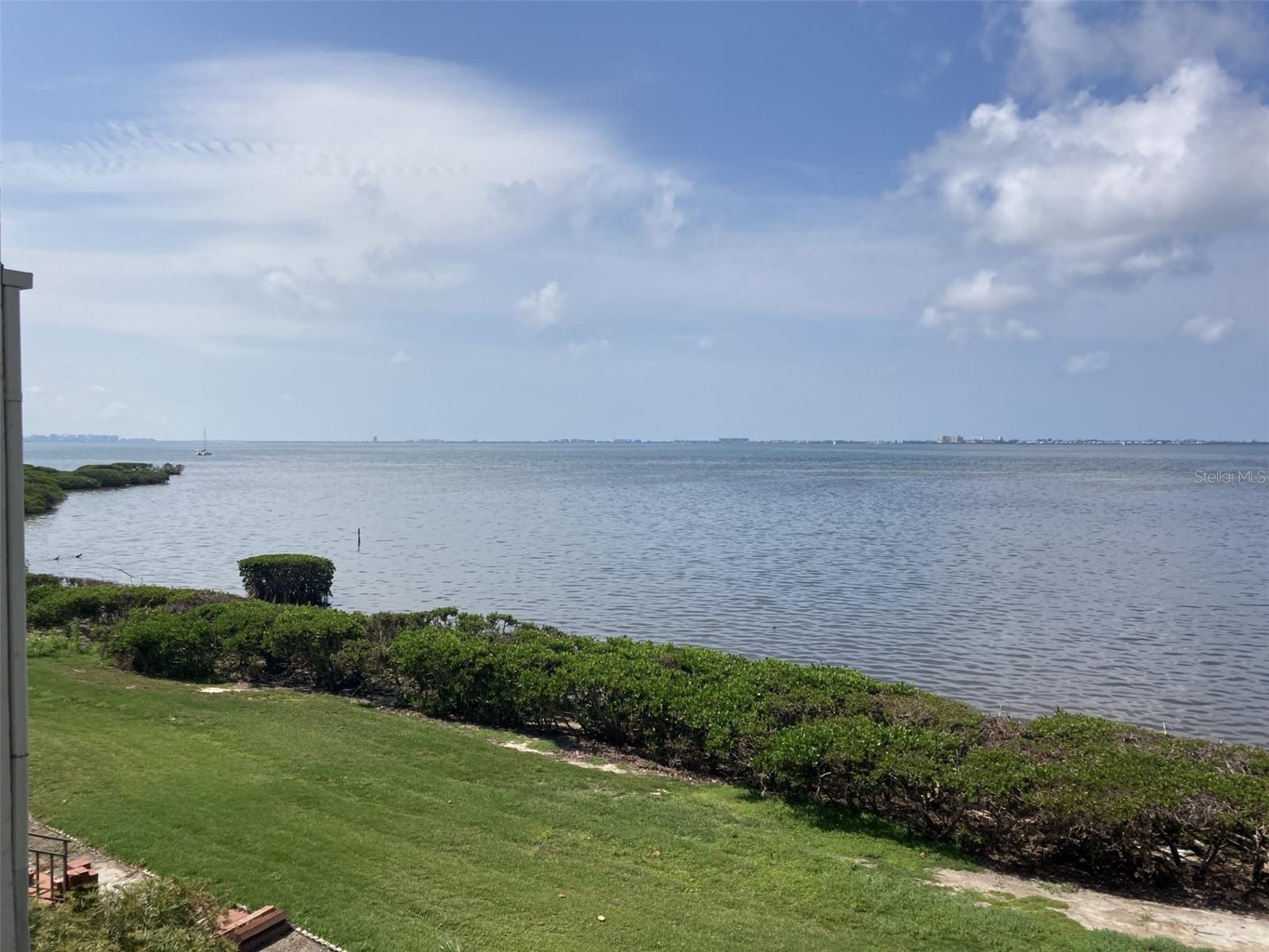 Great opportunity! A million dollar view for half the price! Appraised March, 2025 for $560,000, just reduced by $30,000. Absolutely beautiful panoramic view of Sarasota Bay from this spacious two bedroom - two bath condo in Wild Oak Bay. There is high gloss tile throughout plus the kitchen has been updated with Kitchen Maid cabinets, granite countertops, stainless steel appliances and attractive back splash plus tray ceiling with recessed lighting and ceiling fan. The master bathroom shower has newer tile and sliding doors - master bedroom has a walk-in closet plus another set of closets and most importantly sliding doors to lanai with a view of the bay. Also recently installed are all new hurricane proof double paned windows and sliders. The lanai also has tile floors and a closet which can be used for storage or a small office. There are new blinds on the lanai which are controlled by a wall mounted remote control. There is an open patio in front - perfect for plants and seating. The condo is directly across from the elevator. There is a carport plus guest parking. The condo is located in the IMG Country Club area, which features an 18 hole regulation size semi-private golf course and a clubhouse/grill room overlooking Sarasota Bay. There is also a tennis club in the area. Located near schools, shopping, grocery stores and minutes away from the airport and Sarasota. Approximately 8 miles to the beach. This is an all age condo and allows two large pets. Owner has paid the roof assessment.