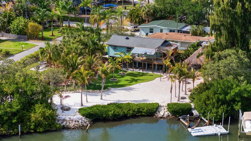 Unique Gulfport Marina District Waterfront Residence. A rare opportunity to own a MOVE-IN READY house on STILTS! Built in 1980, this beautifully landscaped 2-bedroom, 2-bath cottage is located just two blocks from the Gulfport Marina and about a mile from downtown Gulfport. Situated on a rare oversized lot, the home offers exceptional outdoor living and great potential featuring under the home additional space to create your dream outdoor kitchen and more. You'll love the modern features such as recessed lighting, sleek ceiling fans, hurricane impact windows and sliders, modern kitchen design, and a beautifully designed primary en-suite. Outdoor living is exceptional with south facing exposure, sunrises, sunsets, a wrap around porch, huge Tiki gazebo, hot tub, expanse water views, and tropical atmosphere. You'll have more time on your hands relaxing curtesy of effortless maintenance provided by the Astro Turf and crushed shell grounds. Additionally, water sports options abound from fishing off your dock, kayaking or paddle boarding to downtown Gulfport’s restaurants/bars scene or simply bring the boater in you and enjoy easy access to the Gulf and beyond. Life in Gulfport is relaxed, colorful, creative and full of character. This charming waterfront community is known for its vibrant arts scene, walkable streets, and welcoming small-town feel. Residents enjoy waterfront sunsets at the Marina or the Municipal Beach, strolling along the shops and restaurants of Gulfport Waterfront District, and gathering for popular local events like Gulfport Art Walk and the weekly Gulfport Tuesday Fresh Market. With beautiful beaches just minutes away and the culture and energy of St. Petersburg nearby, Gulfport offers a unique coastal lifestyle where art, boating, dining, and community come together to create an unforgettable place to live. Take advantage of this opportunity to own your very own coastal retreat and enjoy the best of Gulfport living.