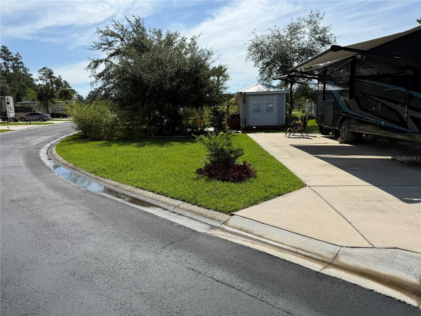 Tucked away in the exclusive The Preserves of Wilderness RV Resort, 10320 NE 28th Loop in Silver Springs offers a rare blend of luxury, comfort, and nature. This oversized corner lot is beautifully landscaped and wrapped in non-invasive bamboo for ultimate privacy. At its heart is a custom cassita that feels like a rustic mini cabin, complete with reclaimed wood-style walls made from stained fence slats and durable vinyl plank flooring. Inside, you'll find a walk-in shower, custom vanity, toilet, and a 10-gallon hot water heater. The entire structure is insulated for year-round comfort, and features a cozy thermostatically controlled electric fireplace with vintage lantern-style lighting, plus a mounted TV that stays with the property.
Step outside to an entertainer’s paradise. The highlight is a one-of-a-kind, hand-sculpted concrete waterfall that begins as a tree trunk and flows seamlessly into a rock formation, creating a serene backdrop. Cross the charming wooden bridge to a stunning paver patio with a fully equipped outdoor kitchen. This space features a wood-built counter with hot and cold water at the sink, a Pit Boss pellet grill, and a griddle-style cooktop—everything you need to cook and host in style. Enjoy cool evenings by the wood-burning fireplace with chimney, all surrounded by lush greenery and the peaceful sounds of nature.
Residents of The Preserves enjoy exclusive access to a private clubhouse, swimming pool, and spa, while the greater Wilderness RV Resort offers a fitness center, recreation room, laundry facilities, bath house, and one of the area’s largest dog parks. Outdoor enthusiasts will love kayaking from Silver Springs State Park—just float downstream and finish right at the resort’s edge along the Ocklawaha River. Hiking and biking trails wind throughout the surrounding natural areas, making every day feel like a vacation.
And when you're ready for a night out, head to The Square in nearby downtown Ocala, where you'll find local restaurants, live music, and weekend events in the park. Whether you’re seeking a tranquil escape or a social, adventure-filled lifestyle, this one-of-a-kind lot offers it all.