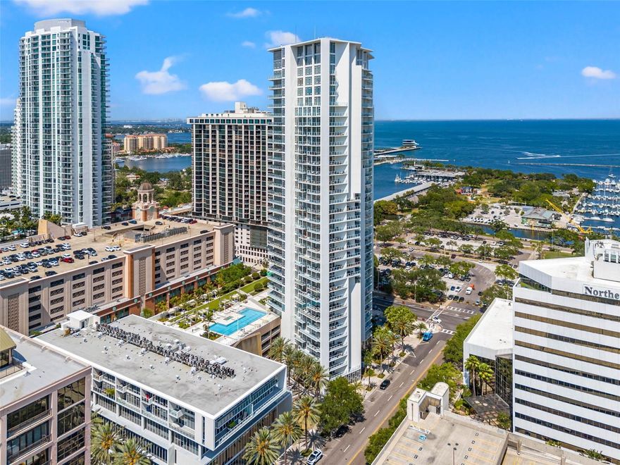 One or more photo(s) has been virtually staged. Located in the iconic Signature Place in the heart of Downtown St. Petersburg, this beautifully designed residence offers a seamless blend of modern luxury and breathtaking city and Tampa Bay views from every space in the home. With a desirable southeastern exposure, natural light pours through dramatic floor-to-ceiling impact glass, highlighting the open and airy 1-bedroom, 1.5-bathroom floor plan with high ceilings and refined finishes throughout. The living space flows effortlessly onto an expansive private balcony spanning the entire width of the residence, creating a stunning outdoor extension where you can enjoy sweeping views of the downtown skyline and sparkling waters of Tampa Bay. The upgraded kitchen is both stylish and functional, featuring a stainless steel appliance suite, sleek quartz countertops, and generous cabinetry, while automated shades throughout the residence provide comfort and convenience. The spacious primary suite captures the same captivating views and includes a large ensuite bath and walk-in closet, while a guest powder room offers added privacy for visitors. Additional highlights include an interior laundry closet, ample storage, one assigned parking space, and a climate-controlled storage unit. Residents of Signature Place—one of Downtown St. Pete’s most recognizable architectural landmarks—enjoy an impressive collection of resort-style amenities, including 24-hour concierge service, a grand lobby, club rooms, a state-of-the-art fitness center, infinity-edge pool and spa, outdoor grilling areas, and a putting green. Just outside your door, the very best of downtown awaits, with Beach Drive, the St. Pete Pier, waterfront parks, museums, dining, galleries, and vibrant nightlife all within easy walking distance, offering a lifestyle where luxury, culture, and waterfront living come together in one of Tampa Bay’s most dynamic cityscapes.