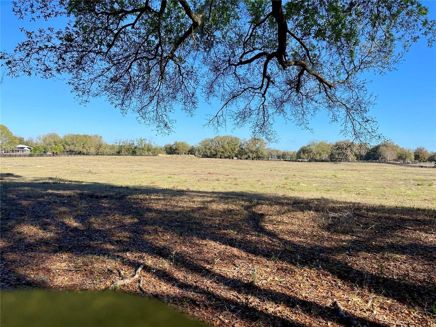 Exceptional opportunity to own 11.95 acres (more or less) of high and dry A-1 zoned land in a PEACEFUL RURAL setting just minutes from The Villages with convenient access to I-75. This beautiful parcel is fully enclosed with a gated entrance and 4-board fencing, making it ideal for horses, livestock, or those seeking space for a PRIVATE COUNTRY ESTATE. Power pole and a deep well installed in 2017 for livestock (approximately 120 feet deep) is already in place, adding immediate functionality for agricultural or equestrian use. Located outside of a flood zone, the property offers both peace of mind and usability. A berm currently used for shooting is located at the rear of the property and could also provide useful fill material for a future homesite. Access is provided by a private paved lane serving the neighboring properties, offering a quiet setting with one way in and one way out, minimizing through traffic and enhancing privacy. !! NO HOA !! Whether you are looking to build a custom dream home, create an equestrian property, establish a small farm, or invest in acreage, this property offers ENDLESS POSSIBILITIES in a highly DESIRABLE location.