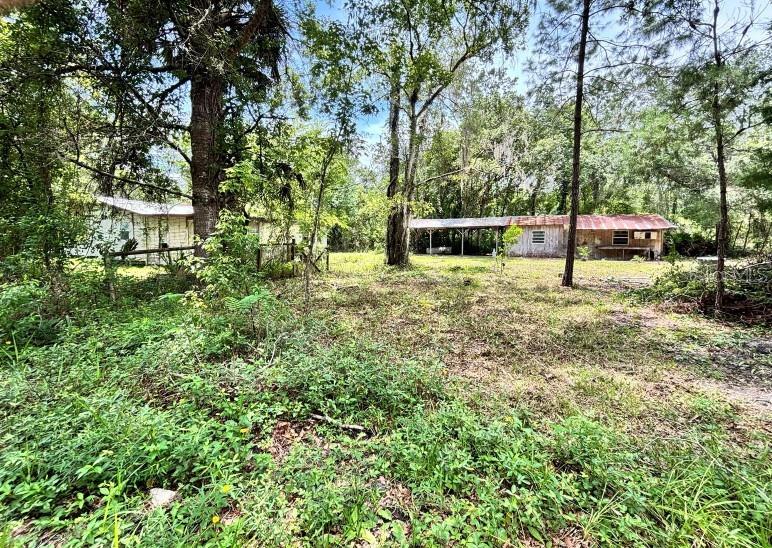 Ready to build with everything in place for your new home, including septic, well pump, and impact fees paid. Per Marion County Zoning and a recent boundary survey, this is a double lot that allows for two homes. Making the possibilities endless! This .51-Acre Lot is located in beautiful Ocala. For those who really love the outdoors, you've hit the jackpot! The Silver Springs State Park nearby as well as the Ray Wayside provides a launch point for canoes and kayaks into the Silver River, which flows into the big Ocklawaha River! For the Ziplining Enthusiasts, The Canyons Zipline and Adventure Park offers zip lining as you soar over two spectacular canyons and 4 lakes! Ocala is also known as the Equestrian Capital of the world! For the horse enthusiast, this is the place to be. This lot offers a great opportunity to build your dream home plus a second home for mom or you can make it an AirBNB in this quiet beautifully treed lot with the feeling of seclusion but on a main road just around the corner from Grocery Stores, Shops, Homecenters, restaurants, Silver Springs State Park and so much more! Impact fees paid for the main house only, pay for the 2nd home impact fees. If you choose to tear down the existing house shell the county gives you up to 5 years to build without paying impact fees. Existing large barn on concrete slab is perfect for a shop or to finish as that AIRBNB. Barn outbuilding has spacious 400 sqft overhang for parking cars or equipment or an outdoor patio space for the AIRBNB. Property has in place a large capacity septic system recently pumped out and certified in good condition with a well and pump in place, you are way ahead of this construction project! The property is surrounded by farms and single-family homes on acreage. Check this out today because it will not last long.