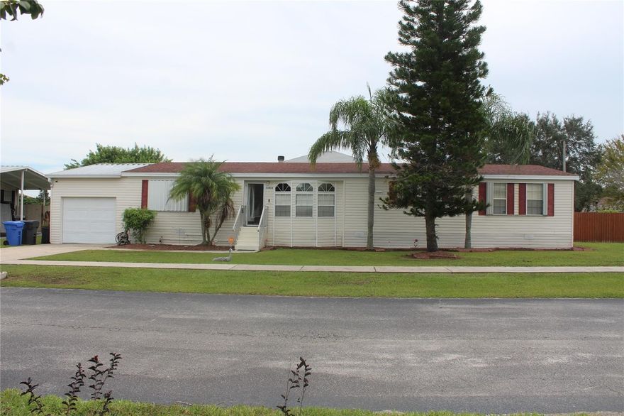 Beautiful updated and completely fenced double wide with an open floor plan on 1/4 acre located on a corner lot with attached one car garage. This home features laminate flooring throughout entire home. When you walk in you enter the formal loving room and formal living room with a corner fireplace and sliders leading out to an oversized large screened lanai. Their open kitchen which leads into another family room area and/ or secondary living room. The master bedroom with a large master bathroom with features a garden bath with separate shower stall and dual sinks along with an oversized master closet.One the other side of the home features 2 more bedrooms, bathroom and laundry room. One of the secondary bedrooms has access to outdoors and would make a great home based office. You don't want to miss this chance to grab up this home which has extremely low HOA fees as well.