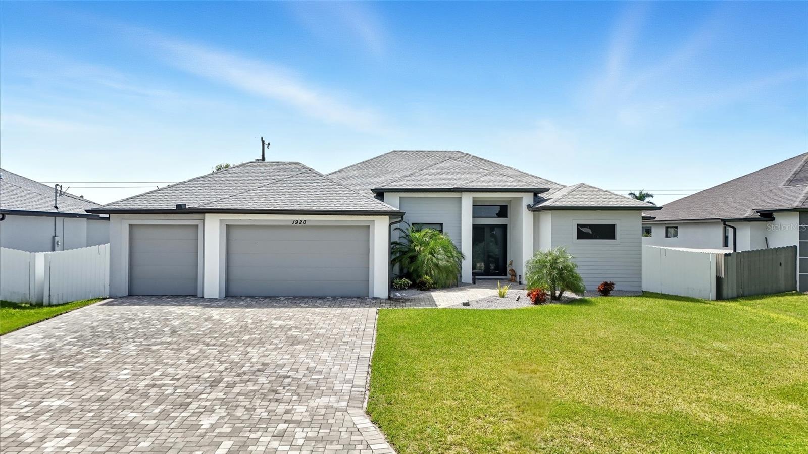 No flood insurance required and all assessments are PAID. This 2023 build is loaded with upgrades inside and out. The oversized saltwater pool is solar heated with two additional panels, keeping it warm enough for swimming year-round. A pavered pool deck creates a resort-style outdoor space and includes an outdoor sink and grill. The backyard is fully fenced and features upgraded landscaping, Floratam sod, and an automatic sprinkler system. Gutters surround the home for complete drainage protection. The interior offers 4 bedrooms, 2 bathrooms, and a 3-car garage. The kitchen and baths feature quartz countertops, soft-close cabinets, and upgraded lighting. Tray ceilings add height throughout. The primary suite includes two shower heads, a soaking tub, and custom shelving in the walk-in closets. The living room has an electric fireplace. Additional upgrades include extended pool pavers with a walkway to the garage, built-in garage cabinets and organizer walls, a 50-amp plug for an RV, and a 220-amp outlet in the fourth bedroom for a sauna (sauna not included). All appliances have been replaced with Samsung Bespoke models. Minutes to Pine Island Road with new shopping such as Farmer Joe’s and Target and many restaurants. Surrounded by new construction homes, this property combines a prime location with high-end finishes and year-round outdoor living.