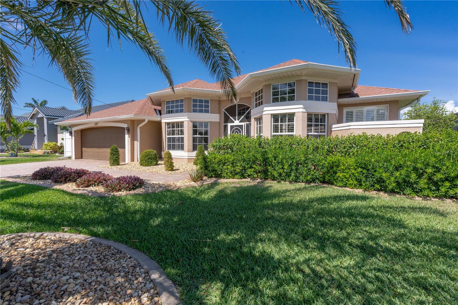 Welcome to your waterfront oasis with Gulf access and no bridges, offering the perfect blend of luxury, functionality, and outdoor living. This 3-bedroom plus den, 3-bath home is nestled on a wide canal and boasts a private boat dock and lift, making it a dream for boaters. Enjoy unforgettable sunsets from your beautiful saltwater pool and spa, all enclosed within a screened lanai for year-round enjoyment.
Step inside and be captivated by the open-concept layout and rich wood laminate floors that flow throughout the home (bathrooms feature tile). The split-bedroom floor plan with volume ceilings creates privacy and openness all at once, perfect for both entertaining and everyday living. Plantation shutters throughout the home add timeless elegance and light control. The heart of the home is a spacious kitchen designed for both style and performance. Featuring cabinetry with crown molding, Quartz countertops, a large cook island with seating, and a high-end gas range, it’s a culinary dream. There’s even a dedicated bar area with glass cabinets and a beverage refrigerator, ideal for entertaining. The primary suite is a true retreat with a walk-in closet, a spa-inspired bathroom featuring a deep soaking tub, an expansive Quartz vanity, and a frameless glass walk-in shower. Two additional bedrooms, three full baths, and a flexible den with ample space for guests, hobbies, or a home office. Additional updates include a new roof (2018), AC unit (2019), and appliances (2021). What truly sets this home apart is the rare 500-gallon propane tank that fuels the gas range and is available for other uses as desired—adding convenience and value. Step out to the covered patio with paver flooring and ceiling fans, the perfect setting for poolside dining or relaxing while taking in tranquil sunset views over the canal. Whether you're boating, entertaining, or simply enjoying the serenity of waterfront living, this home offers the ultimate Florida lifestyle.
