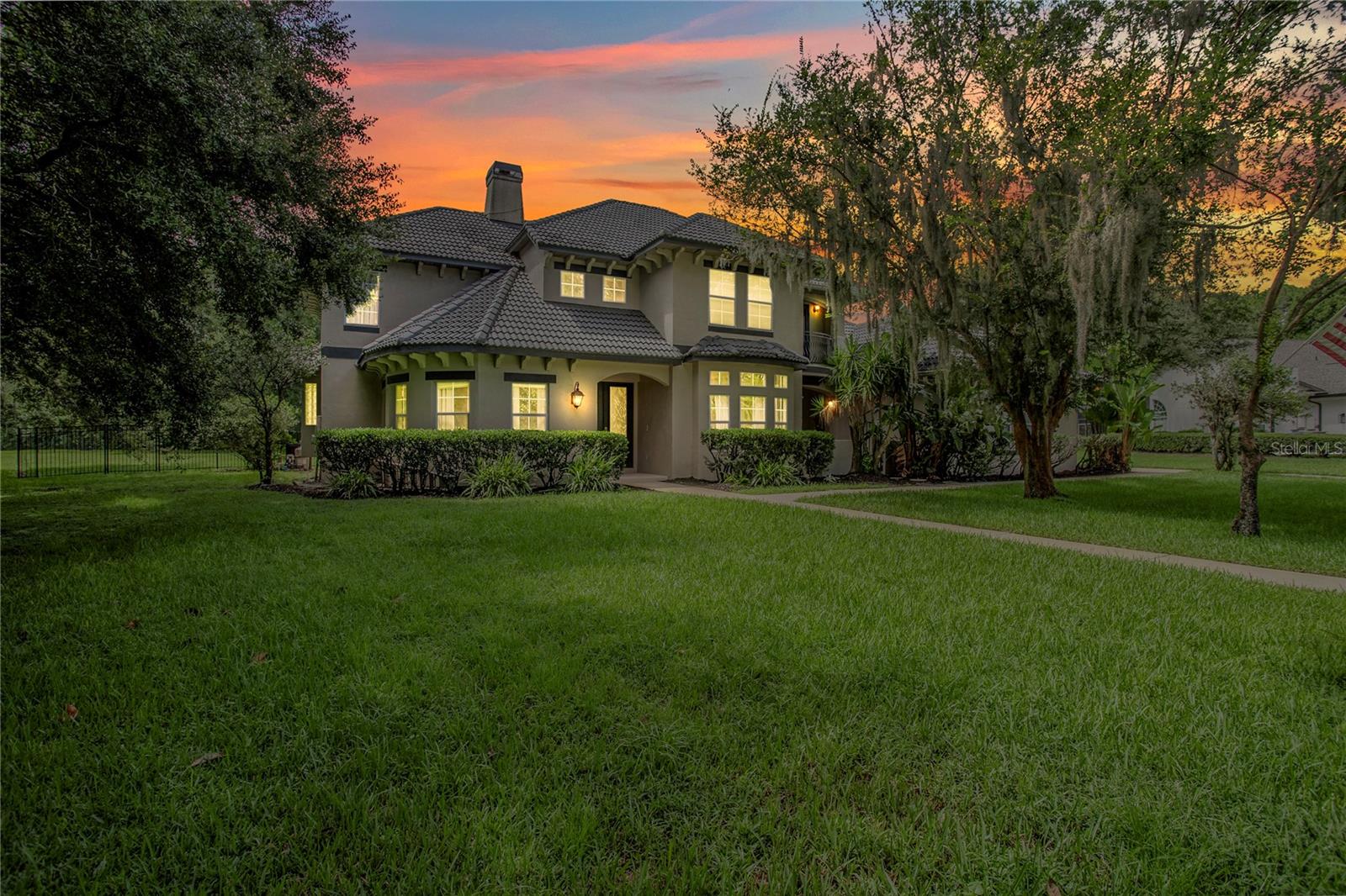 Elegant & spacious 6BR/4.5BA estate on 1+ acre in Windermere Downs, a highly desirable community favored by buyers for its prime location and refined lifestyle. The long, circular driveway welcomes you to soaring ceilings, hardwood floors, and a beautifully designed kitchen featuring solid surface sablestone countertops, tile backsplash, and maple cabinetry with 36" & 42" uppers topped with crown molding. All bathrooms feature cultured marble countertops. A cozy wood-burning fireplace adds warmth to the family room. The first floor offers a welcoming foyer with a living room and a beautifully designed formal dining room as you enter the family room with the fireplace. The primary suite is located on the first floor and includes dual sinks, a custom-designed closet, and a spa-style clawfoot tub and separate shower stall. On your right, the guest bedroom/study shares an adjoining pool bathroom. Upstairs features a loft/media room and four additional bedrooms—two sharing a Jack & Jill bath and two sharing a hallway bath—each with walk-in closets. The spacious three-car garage provides ample room for your vehicles and extra storage needs. Enjoy a fully fenced backyard with a heated pool and spa jacuzzi with massaging jets—ideal to help you unwind after a long day. Additional highlights include a surround sound prewire system for the home theater, durable tile roof, two central AC units, two water heaters, and a brand new washer & dryer that will convey with the home. The outdoor area features a summer kitchen and no rear neighbors for peaceful privacy. Residents enjoy exclusive lake access, tennis courts, and a community park. Conveniently located near Stoneybrook West Parkway with easy access to shopping centers including popular retailers and stores, diverse dining options from casual to fine cuisine, healthcare facilities, and about 30 minutes to Orlando International Airport and under 25 minutes to theme parks and vibrant downtown Orlando. A Home Warranty with a comprehensive Total Plan coverage conveys, protecting major systems and appliances through 11/7/2029. Schedule your private showing today to experience this remarkable estate firsthand!