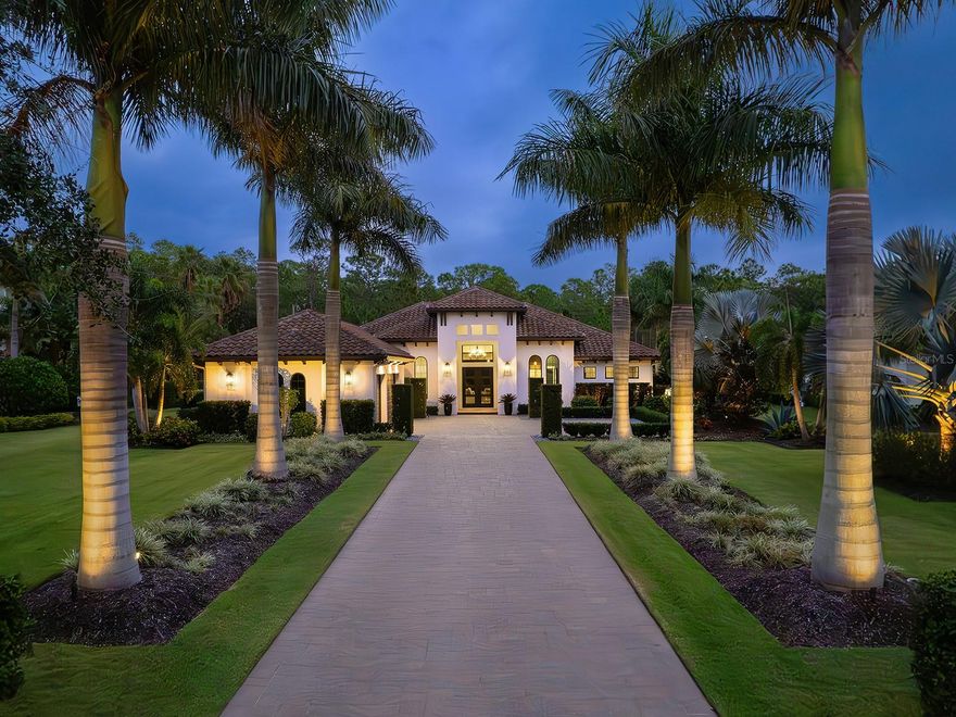 Located in The Concession, one of the area’s most prestigious communities and home to the Concession Golf Club, this exquisite property is impressive from the moment one arrives onto the long paver drive bordered by mature, meticulously manicured landscaping. Once inside, the grand entrance features a high ceiling adorned with an impressive chandelier and mirrored accent wall, setting the tone for the luxurious interior. The great room is a focal point of the house, featuring a stone fireplace surrounded by custom trim, built-in shelves, and a tray ceiling with crown molding. 10’ feet tall by 22’ wide sliding glass pocketing wall system and porcelain tile flooring add to the elegance and functionality of the space. The adjacent dining area is designed for both style and functionality, featuring a tray ceiling, a dry bar with a granite top, and a mirror tile backsplash that adds a touch of glamour. The kitchen is a chef's dream with white cabinets featuring pull-out shelves and soft-close drawers, quartz countertops, stainless steel Thermador appliances, and a huge island in a contrasting color with storage and counter height seating. Lit glass top cabinets showcase fine dishware, and a 10’ tall glass encased wine display adds a touch of luxury. The white tile backsplash extends to the ceiling, complemented by large windows and a big custom-organized pantry. The bonus room features a tray ceiling, a see-through wine display accessible from both sides (connecting to the kitchen), and 10’ tall by 12’ wide sliding glass pocketing wall system. The primary suite is a luxurious retreat with access to the lanai, two custom-organized walk-in closets, a spacious marble vanity, windows, crown molding, a huge dual-entry shower, a water closet, and a free-standing tub. The office exudes sophistication with dark walls, large windows, a high ceiling with crown molding, and glass doors for a refined and private workspace. Each of the two guest bedrooms has generous closet space and en-suite bathrooms that also open to the hallway. The laundry room is both stylish and functional, boasting quartz countertops, sink and ample cabinet space. A huge storage room by the garage and another large closet add to the home's practicality. The lanai is an outdoor oasis with travertine flooring, a heated large rectangular pool with lights, a spa, and an ultraviolet light pool system. An island with tons of storage, a granite top, a Blaze professional grill, a Marvel outdoor fridge, a prep sink, and a huge vent hood make outdoor entertaining a breeze. The expansive backyard is beautifully landscaped for a serene ambiance. The Concession, home to the 2021 PGA Tour World Golf Championship and the 2023 PGA World Champions Cup, is one of the most prestigious golf communities in the country and provides the perfect setting for those who admire a serene and tranquil environment.