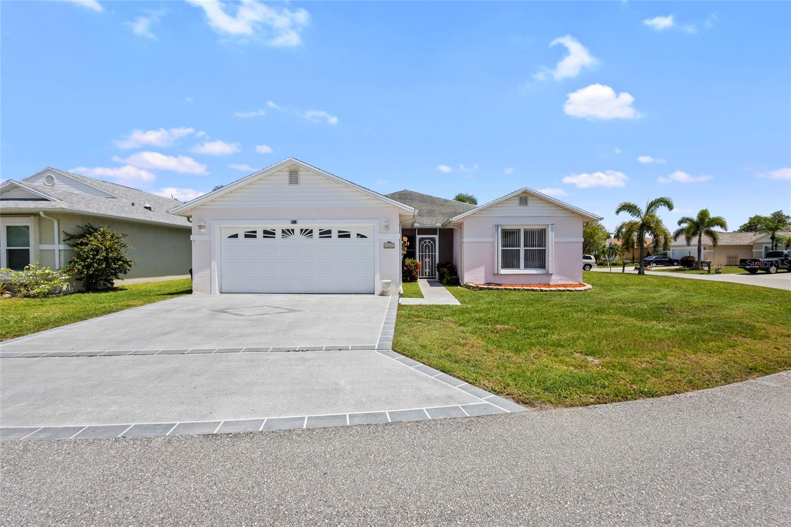 Welcome to the wonderful community of Spanish Lakes! This lovely, move-in ready home offers the perfect blend of comfort and Florida charm. Inside, you'll find three bedrooms and 2 bathrooms, along with a convenient two-car garage. The highlight is an amazing Florida room, ideal for relaxing and entertaining guests. This home also features practical updates, including a new AC unit installed in 2024 and a newer hot water heater. It's also available partially furnished for an easy transition. For added peace of mind, accordion storm shutters are installed throughout. This property is on a land lease within an active community, offering resort-like amenities in a beautiful and quiet setting. The monthly lot rent is an attractive $595.86. Spanish Lakes boasts a fantastic location, close to a variety of shopping options and excellent restaurants, allowing you to truly enjoy the Florida lifestyle. Come and experience the best of Florida living today!