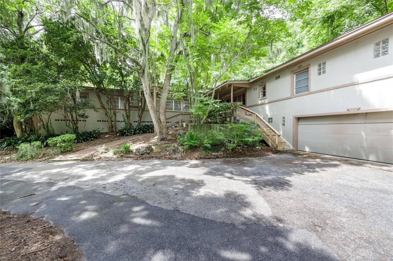 INVESTORS!!! Discover this spacious 6-bedroom, 7-bathroom home in the highly desirable Colclough Hills neighborhood. Nestled on just under an acre, this property offers exceptional privacy while still being less than 10 minutes from both UF and Shands. The main home features 4 bedrooms and 4 bathrooms (3 having their own ensuites), providing plenty of room to spread out. In addition, there are two attached studio apartments—each with its own private entrance, living room, kitchen, and bathroom—making them perfect for guests, extended family, or rental opportunities. Inside, the home boasts a mix of tile and wood flooring throughout, combining style with easy maintenance. A spacious 2-car garage provides ample storage, while the circular driveway offers generous parking for family and visitors. With multiple living spaces and private accommodations, this property is truly an entertainer’s dream. While the home does need some TLC, its size, layout, and location make it an incredible opportunity that won’t last long. Call today to schedule your private showing!