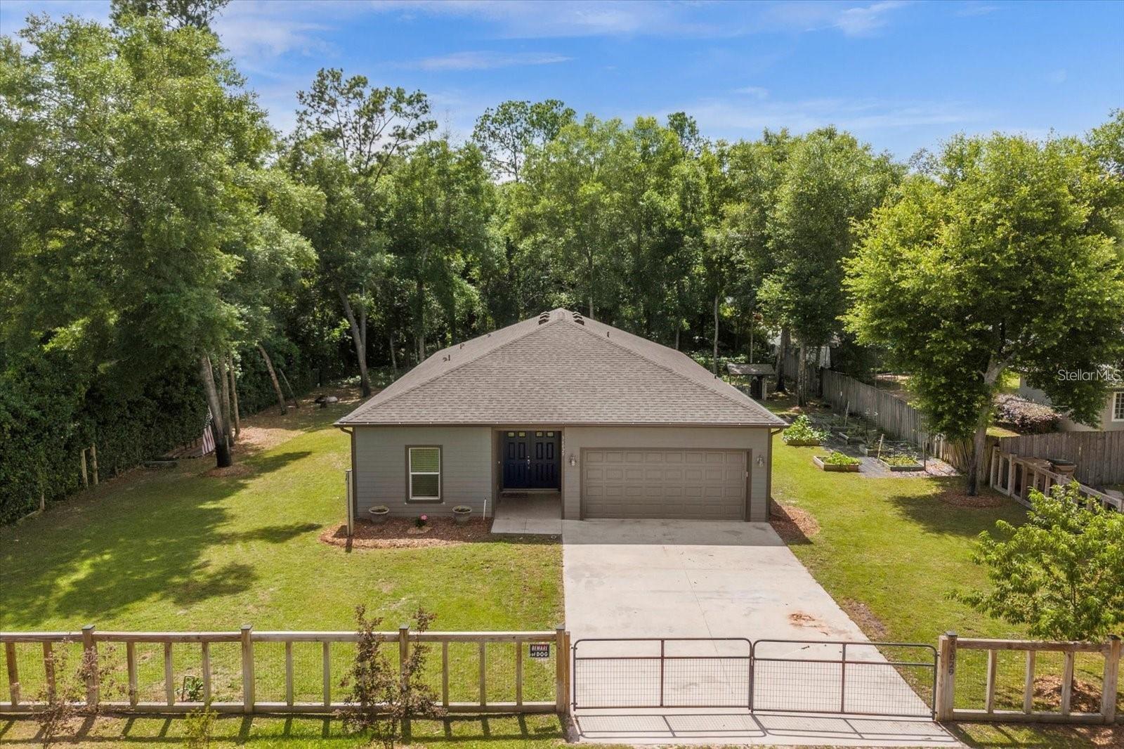 NO HOA, Fully Fenced, and Luxury Finishes—Your Private Eustis Awaits!
Step into privacy and elegance in this stunning 4-bedroom, 2.5-bathroom home, perfectly set on a fully fenced, gated .32-acre lot surrounded by serene greenery. With high-end touches throughout—including ceramic wood plank tile in common areas and plush carpet in bedrooms—this property offers the perfect blend of luxury and comfort.
The open-concept kitchen is a chef’s dream, showcasing granite countertops, 42" shaker-style soft-close cabinets, a spacious island with breakfast bar seating, and a charming breakfast nook leading to the covered lanai. Adjacent, discover a stylish coffee/dry bar featuring glass-front cabinets and extra storage. The dining area effortlessly connects to a spacious great room, ideal for gatherings, and a guest powder room adds convenience.
All bedrooms are generously sized, with a guest bath that boasts quartz countertops and beautiful tile detailing. Your primary suite is a luxurious retreat complete with a spacious walk-in closet and spa-like bath featuring dual quartz vanities, a dedicated makeup space, and a tiled rainfall shower.
Step outdoors into your backyard oasis—a private haven featuring a deck with covered pergola, separate playground area, and a charming garden space. The home also includes a full water treatment system with iron breaker and softener.
Enjoy easy access to SR 429 from this exceptional location that combines convenience, style, and complete privacy without HOA restrictions. Schedule your private tour today!