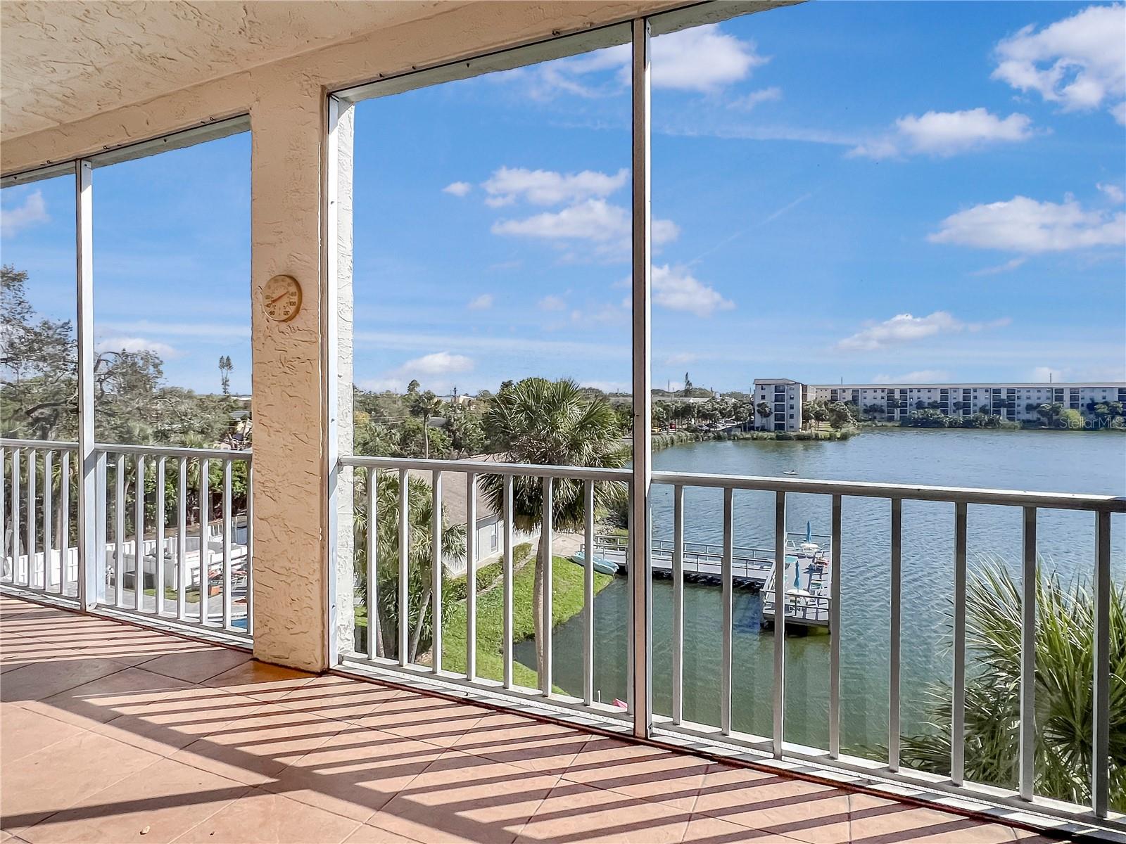 BEAUTIFUL WATER VIEWS! 4TH FLOOR UNIT! FULLY FURNISHED! LOWER HOA FEES IN THIS BUILDING! Welcome to Bayshore On The Lake, a well established 55+ community just a few miles from our renowned Gulf beaches. One of the best buildings in this community... well managed and well located. This spacious, bright, and open condo offers 2 bedrooms and 2 bathrooms with the option to include the furniture for a seamless move-in process. Gently used for only a couple of months each year, this unit is primed and ready for a new owner and has not been used as a rental by the current owner. Separate yourself from the rest with an unbeatable lake view, perfect for morning coffee or evening cocktails. The rear screened porch is large and spans the width of the unit. Also just steps away from the community pool and clubhouse for added convenience. the low hoa fees even come w/ cable and internet included! Local dining, shops, and destinations are just a stones throw away. Surrounded by everything but still feels as if you're a world away. Perfect unit for a variety of lifestyles... full-time, part-time, or future investment. Elevator access in the building makes reaching your new 4th floor unit a breeze. Come see this premium unit and find out why this community is highly desired. Schedule your showing today!