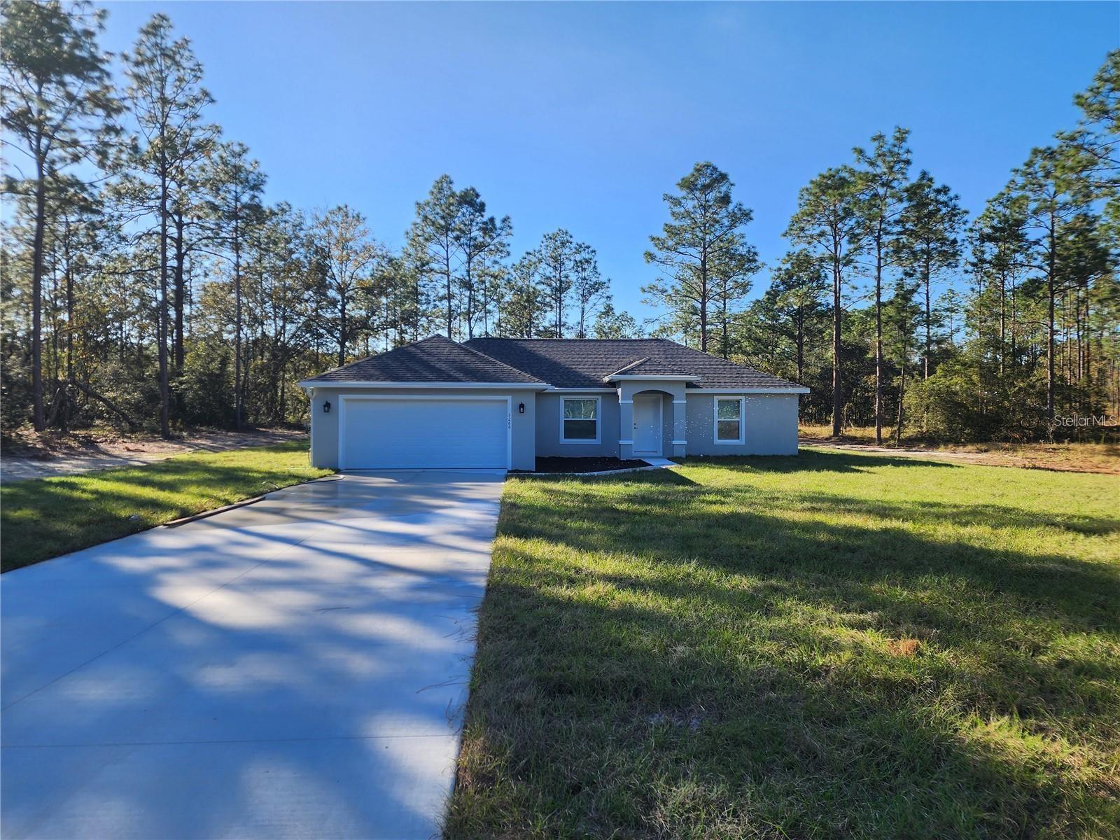 BRAND NEW! - EASILY OBSERVABLE, BETTER VALUE! This Beautifully designed 3 Bedroom, 2 Bath, split bedroom HOME, is nestled on a .99 acre, semi-private homesite in Rainbow Lakes Estate. 20723 SW Audubon Ave. in Dunnellon, boasts 1,880 Sq. Ft. of fabulous features and upgrades! There is a well, septic system, waster softener and plenty of room for a pool. This HOME offers an attractive hip roof, front entry, accent stone at the columns, two-car garage, block construction, hand troweled stucco finish, gutter/downspout, double pane insulated windows, and colonial style windows on the front elevation. As you enter this open and spacious, split bedroom home, you are welcomed into 1,407 sf. ft. of living space, vaulted ceilings, interior laundry room with washer and dryer hook-ups, linen closet and shelving. Enjoy this lovely kitchen with gorgeous granite, single under-undermounted stainless steel kitchen sink, pull-out faucet, white cabinetry, self-close doors and drawers, bump-up over the range, decorative hardware, and stainless-steel appliances (side by side refrigerator with ice-make and water in the door, microwave, dishwasher, glass stop range and disposal). Large ceramic tile flows throughout the home with plush carpeting in all the bedrooms. The primary suite offers a large walk-in closet and the primary bathroom showcases a double "adult height" vanity, granite countertops, undermounted sinks, tiled shower, and adult-height commode room. The other two spacious guest bedrooms, each offer a walk-in closet, light (pre-wire for fans) and share the guest bathroom. The guest bathroom features an adult-height vanity, granite countertops, undermounted sink and ceramic tiled tub/shower. You will love that the home has blinds on all of the windows and doors, making this home MOVE-IN READY! enjoy your evenings with family and friends grilling out on the rear patio. Let's make this HOME YOURS! CALL TODAY!