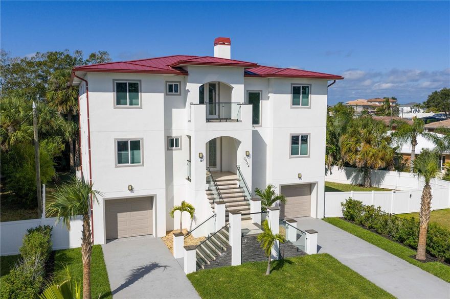 A modern coastal masterpiece in the heart of Dunedin, moments from Honeymoon Island, Main Street’s cafés and boutiques, and the golf course across the street. This new construction home blends architectural beauty and everyday function with five bedrooms, five baths, impact windows, a private elevator, and 48-by-48-inch designer tile floors. The open living spaces rise beneath double-height ceilings with walls of glass and artful light. The chef’s kitchen features granite counters and seamless flow to the great room. A six-car garage and RV or boat parking offer rare versatility. The bamboo-lined backyard provides space for a custom pool. Across the street, explore the Pinellas Trail stretching from Tarpon Springs to St. Petersburg. Caladesi and Clearwater Beach await, where sunsets and serenity define your everyday life.